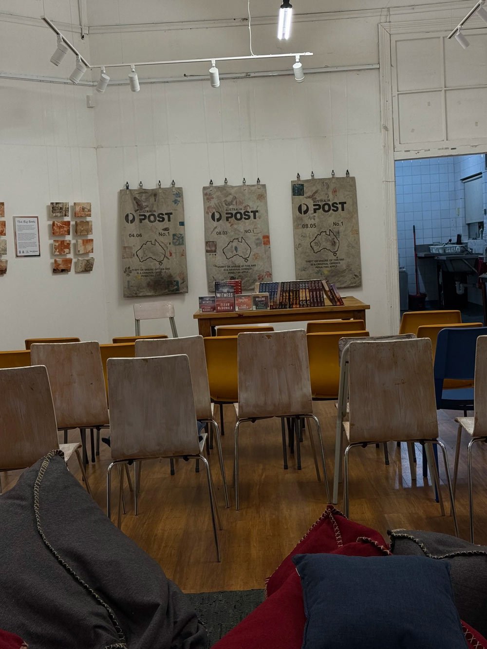 The back view of an event room, the backs of chairs and lots of books up the front