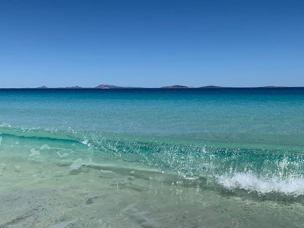 A clear blue ocean wave rolling in