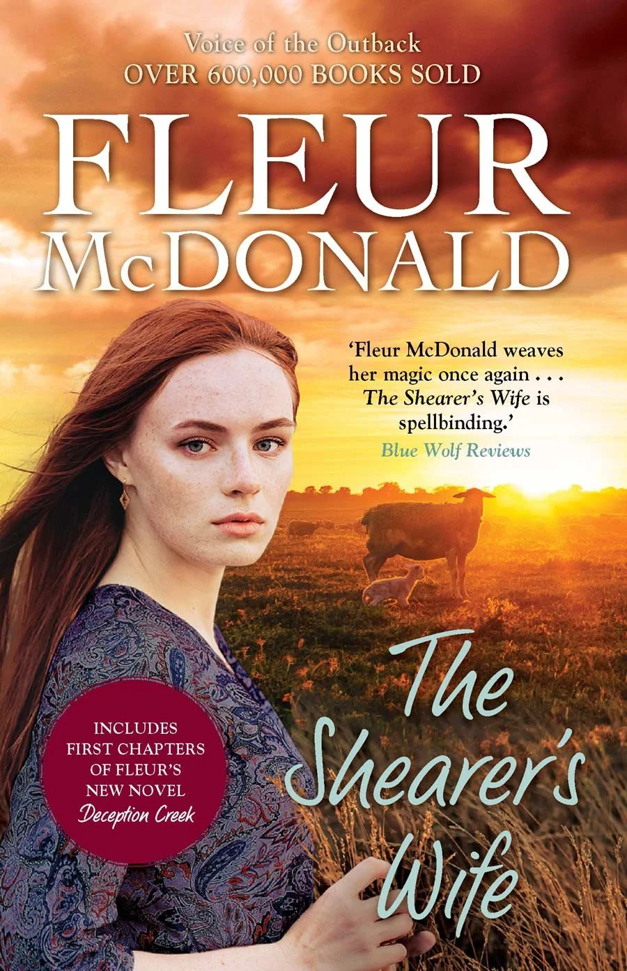 Book cover for 'The Shearer's Wife' by Fleur McDonald. Features a young woman with long red hair, wearing a paisley blouse, standing outdoors during sunset with a sheep and her lamb in a field.