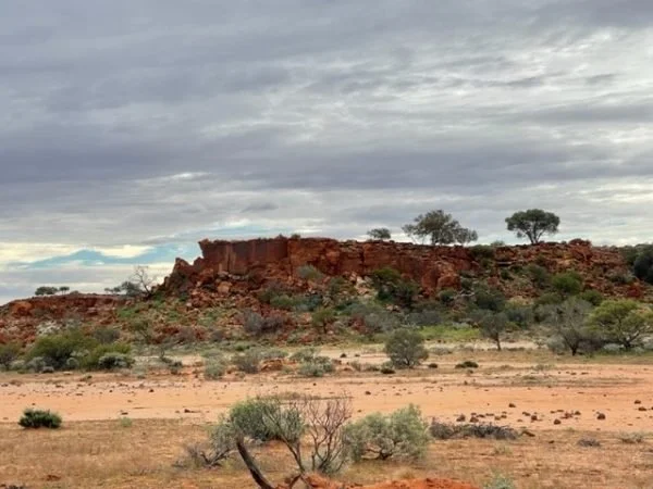 A grey sky over rocky hills