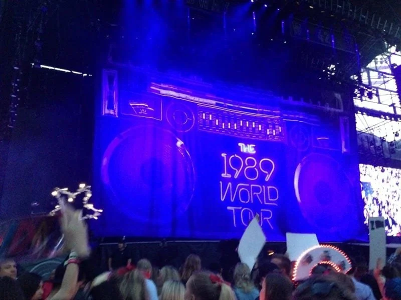 A lit up stage with 'The 1989 World Tour' lit up in neon