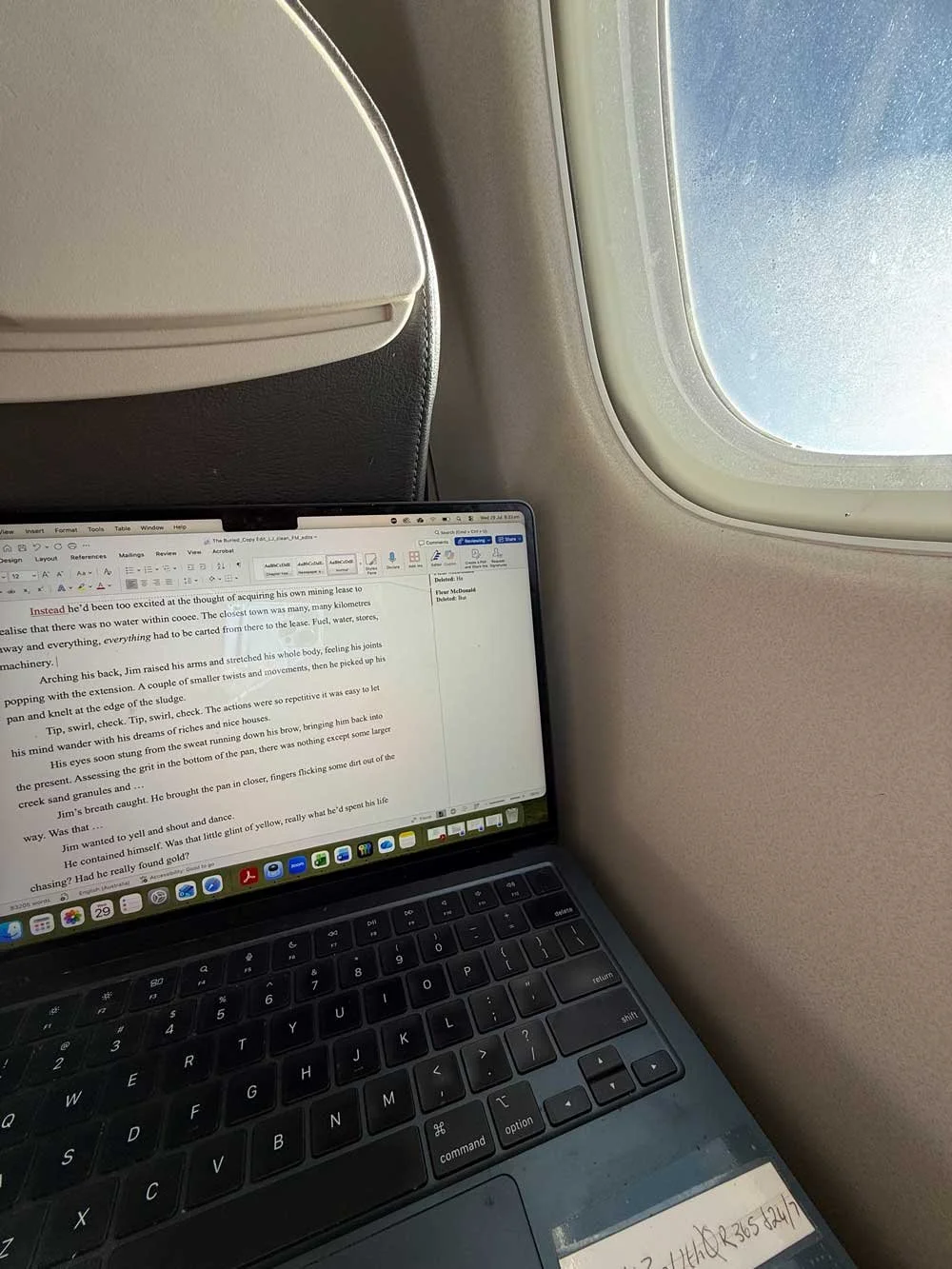 Laptop open next to the window on a plane - Fleur is working on the edits for her latest book