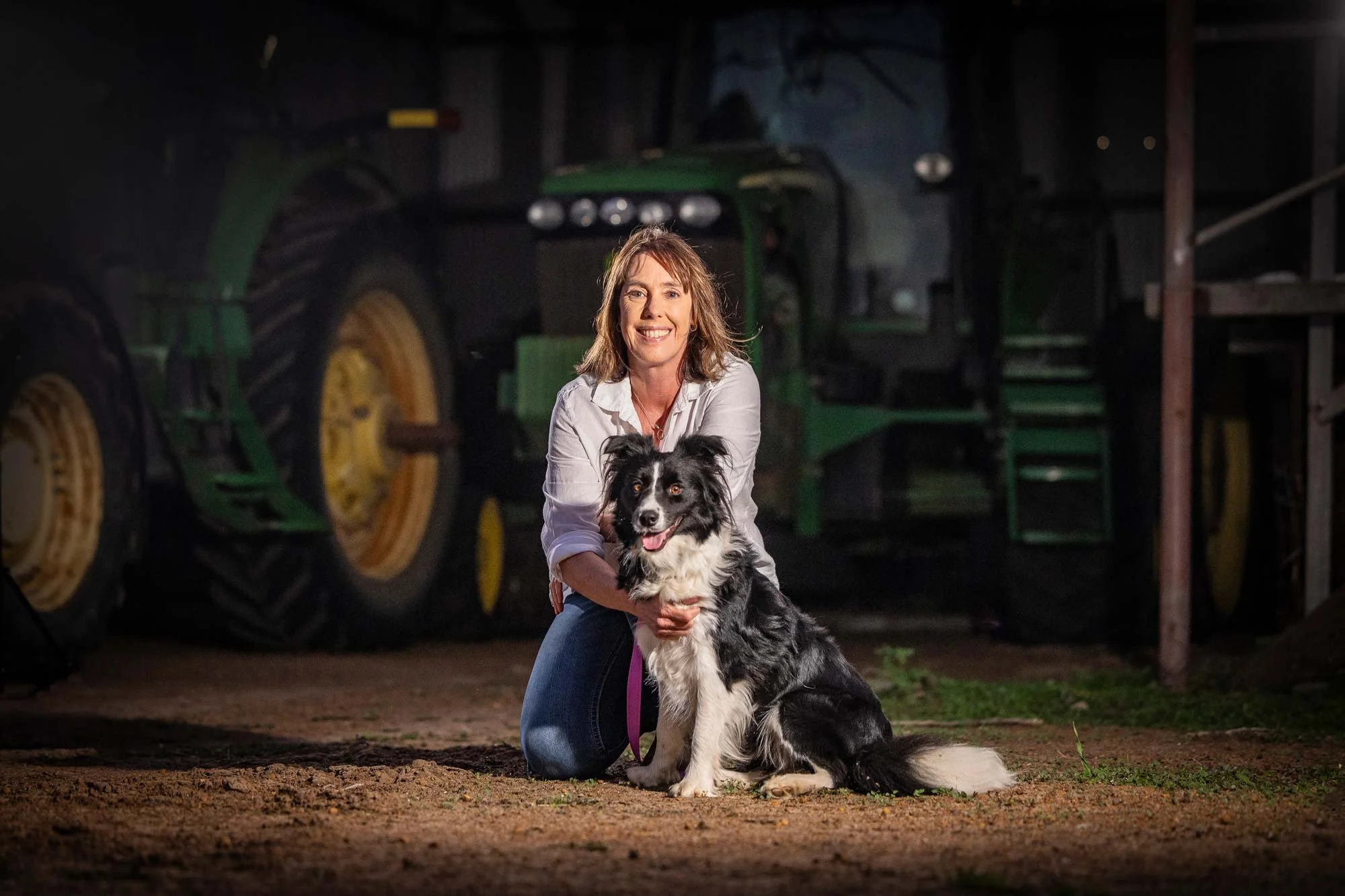 Read Author Fleur McDonald Books In Order - Fleur sits with her dog Shadow. She is smiling big.