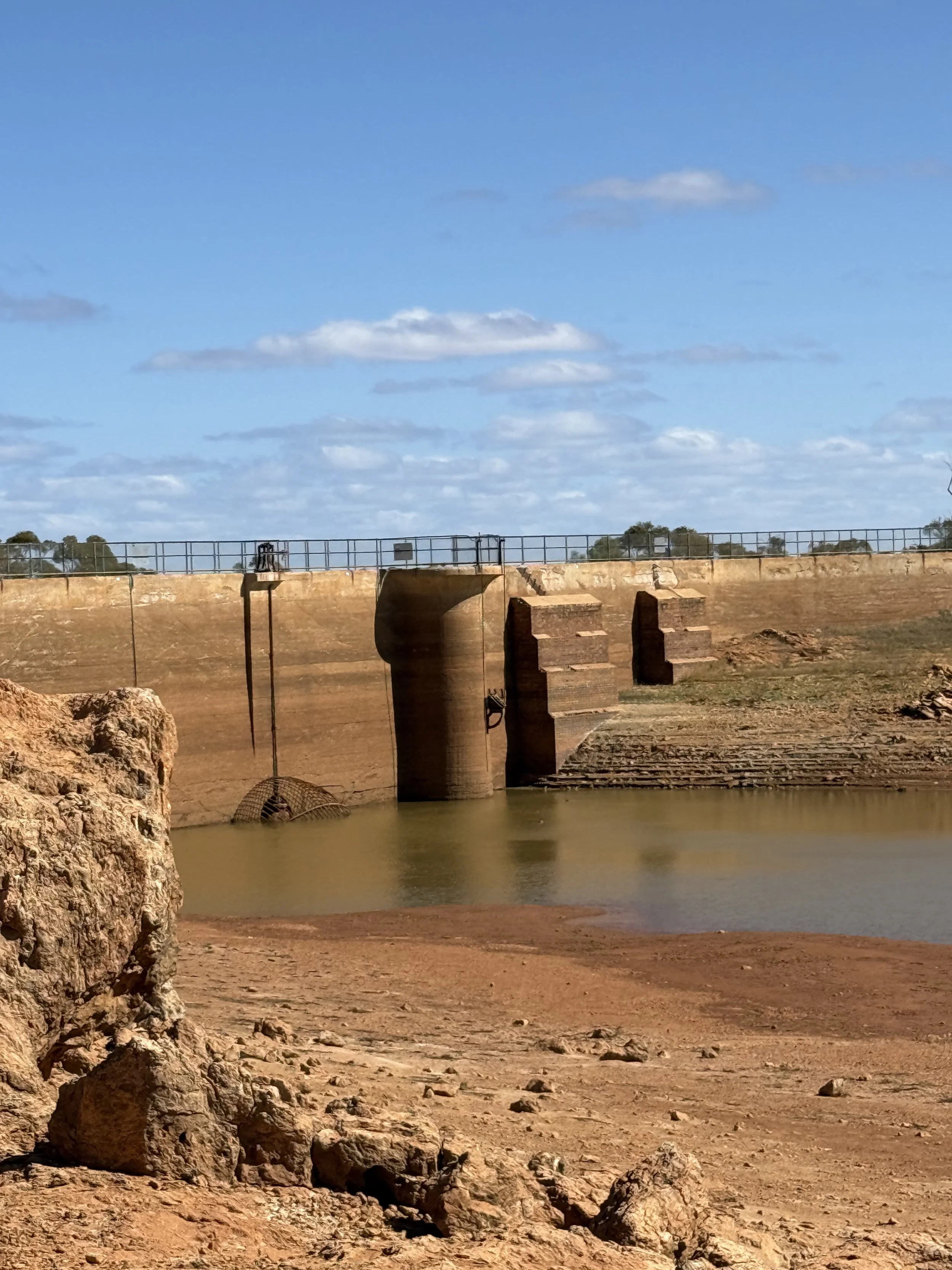 Niagara Dam. Low water, cement bridge with a walkway over the top, blue clouds sky