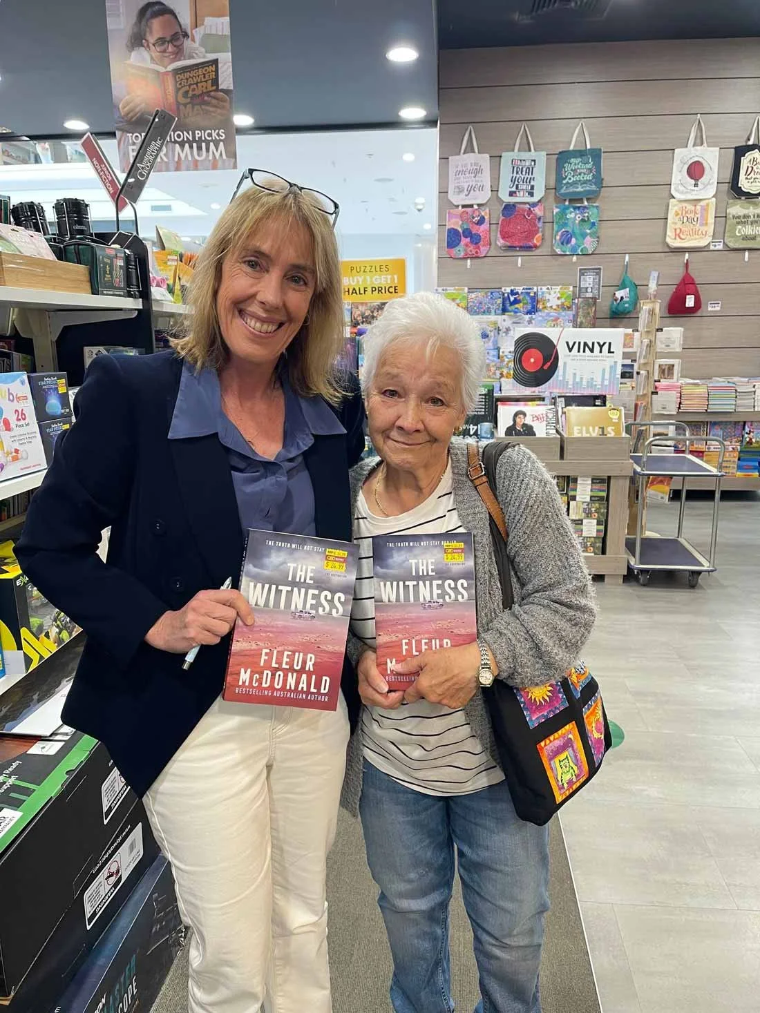 Fleur stands smiling next to a beautiful older lady. They're holding copies of The Witness