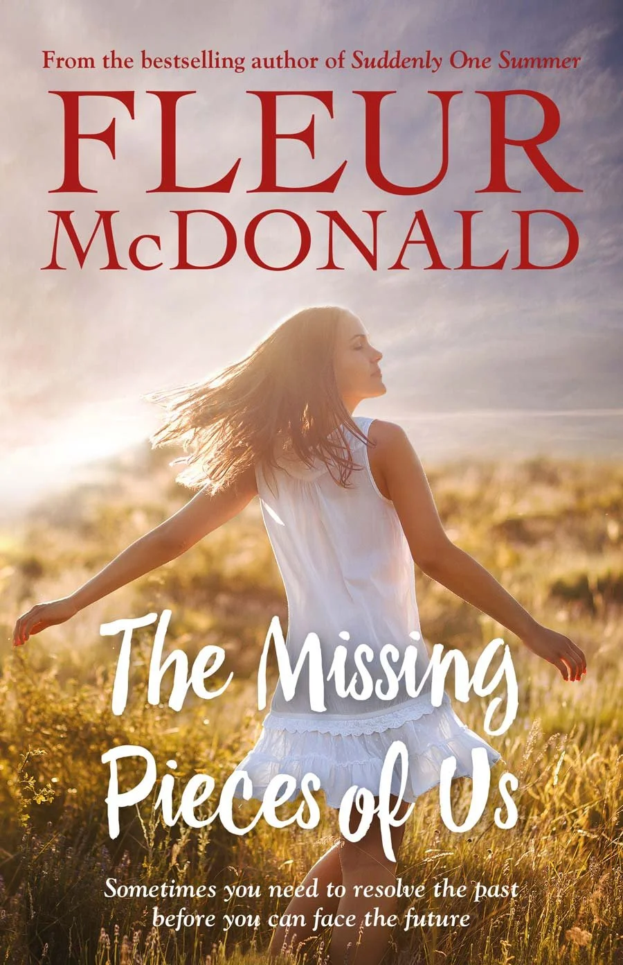 Book cover featuring a young woman with long hair in a white dress standing in a field at sunset, with the title 'The Missing Pieces of Us' and author's name 'Fleur McDonald' written in large red and white fonts.