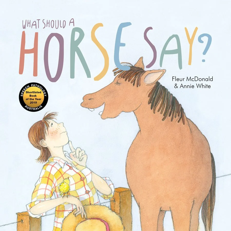 Book cover titled "What Should a Horse Say?" by Fleur McDonald and Annie White, featuring an illustration of a girl with freckles and a yellow checkered shirt, holding a hat, and a horse facing her, on a light background.
