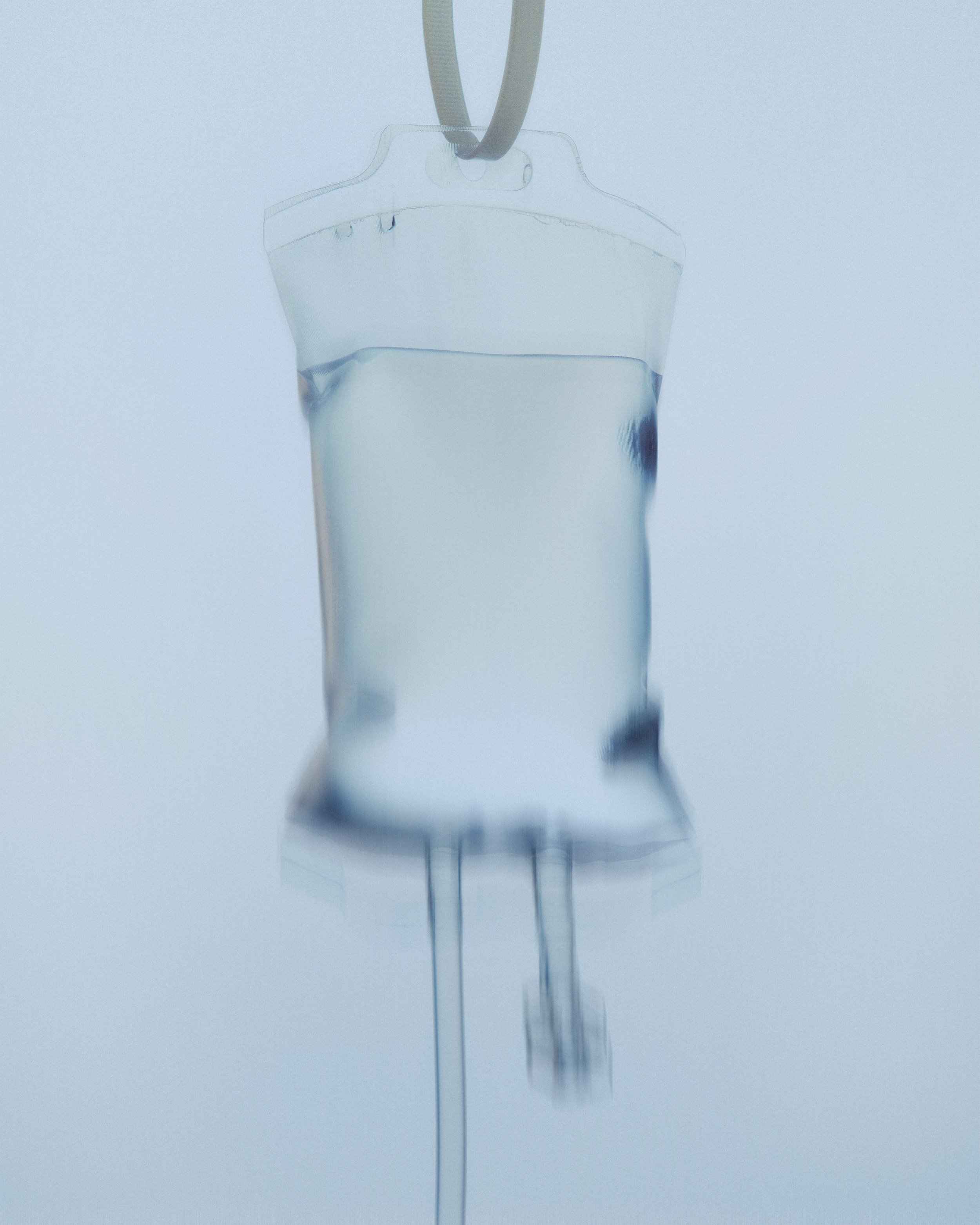 Hospital IV drip with a bag of IV fluid hanging on a stand.