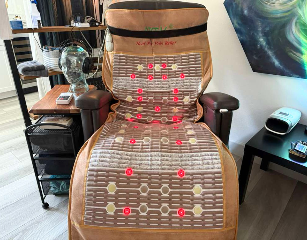Infrared heat massage chair with red LED lights in a home setting.