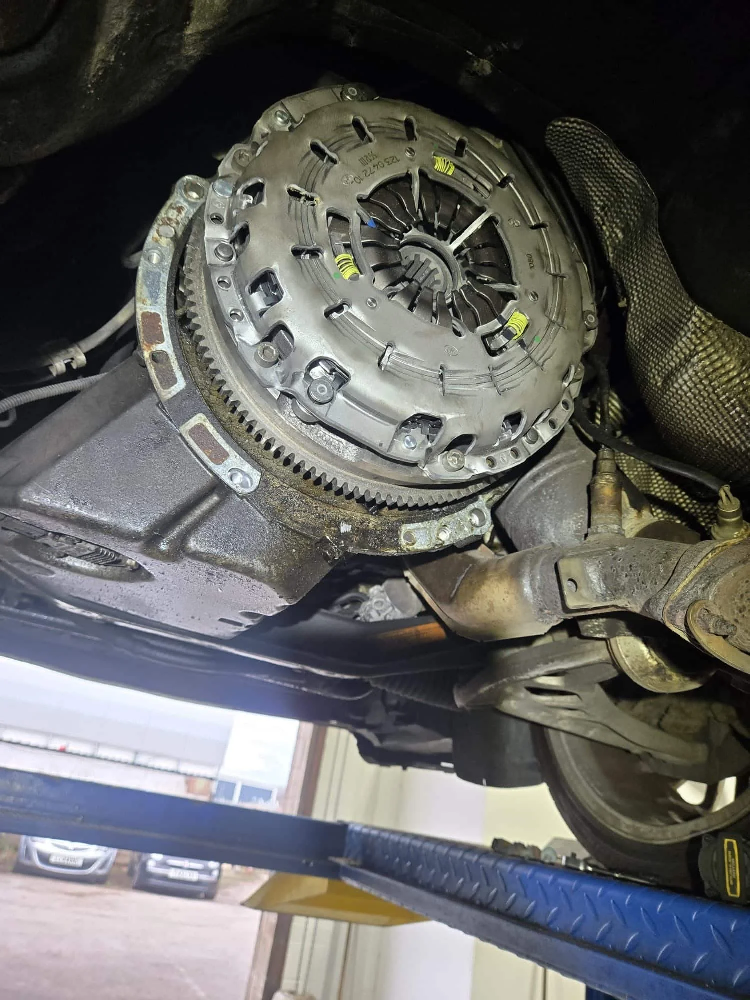 New clutch and dual mass flywheel freshly fitted to a BMW at Premier Tyres Spondon, with the gearbox removed exposing the components before reassembly.
