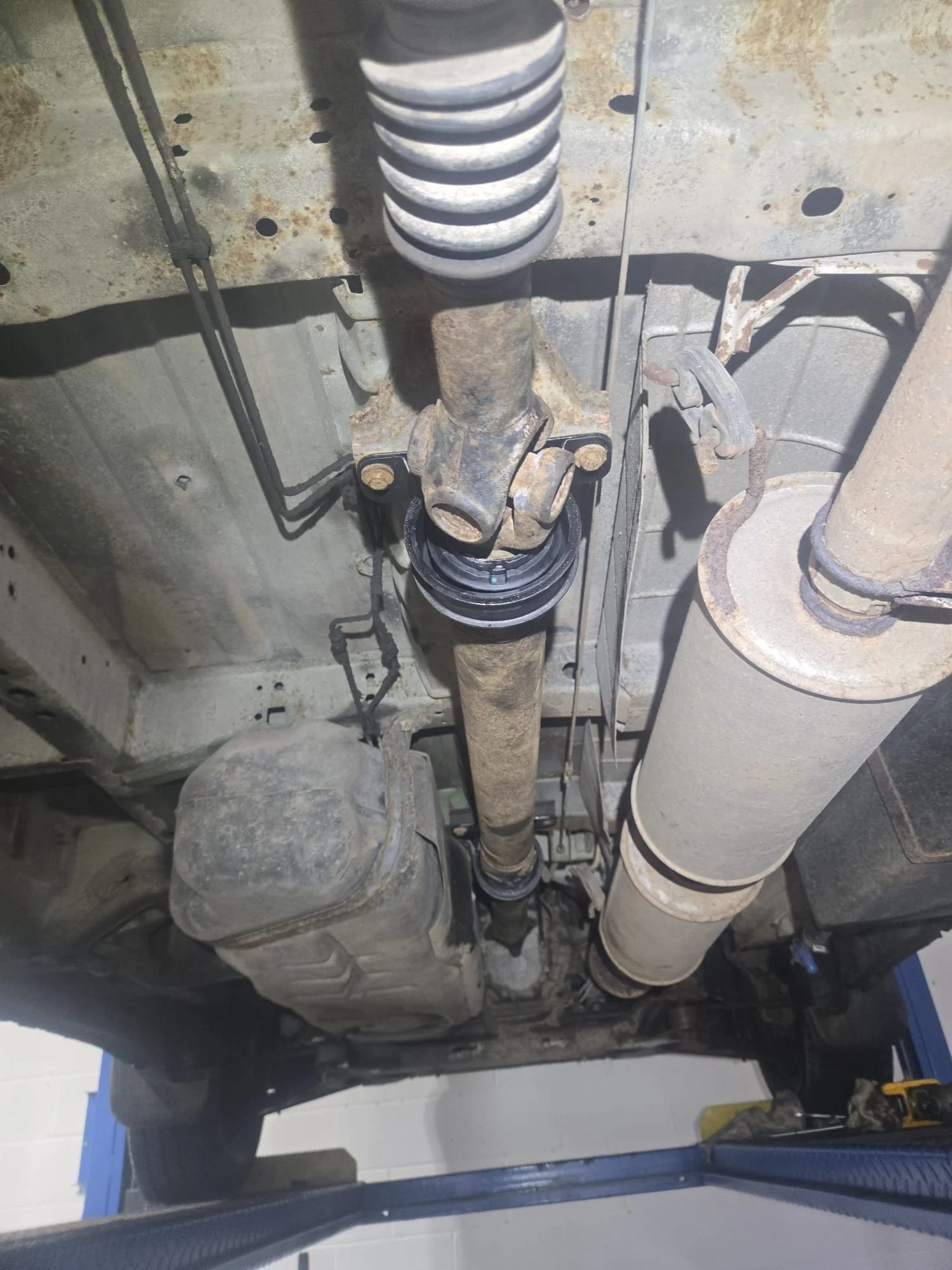 Collection of worn propshaft parts including a damaged CV joint and centre bearing removed from vehicles at Premier Tyres Spondon in Derby.