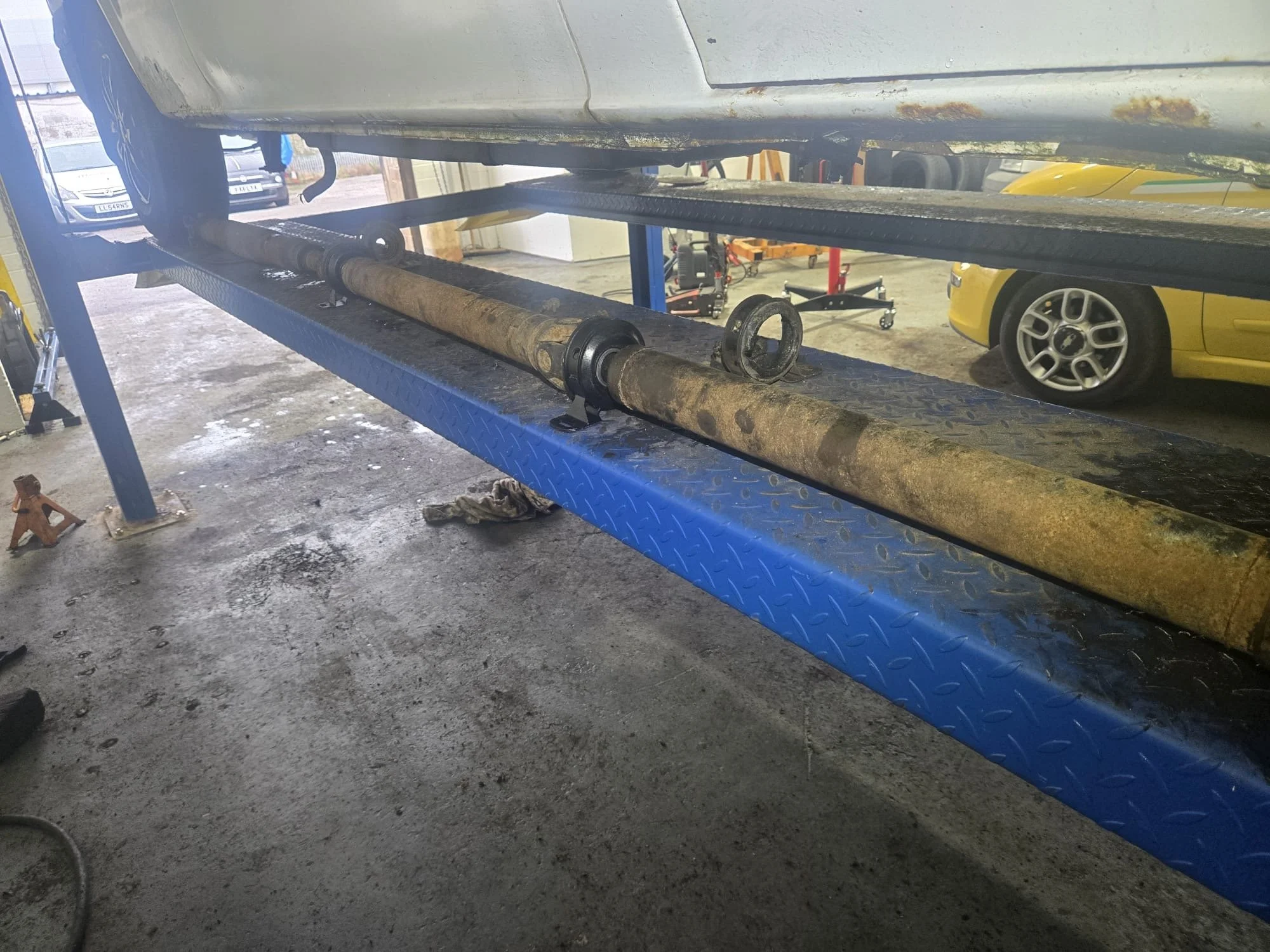 Skilled mechanic performing a propshaft replacement on a commercial vehicle at Premier Tyres garage in Spondon, Derby.