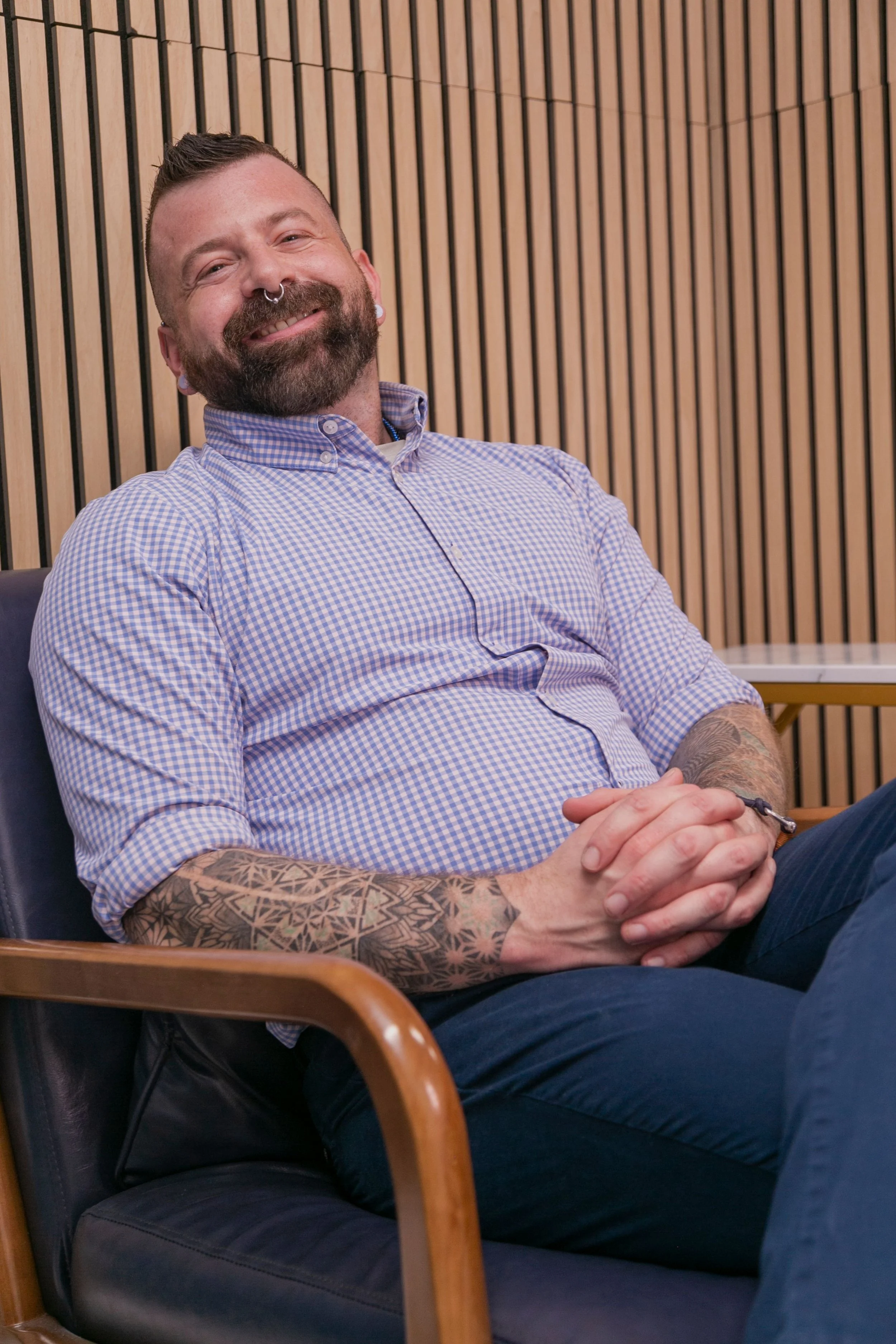 Primary care and mental health clinician seated in a modern medical office, representing inclusive, patient-focused care for adults in Alaska and California.