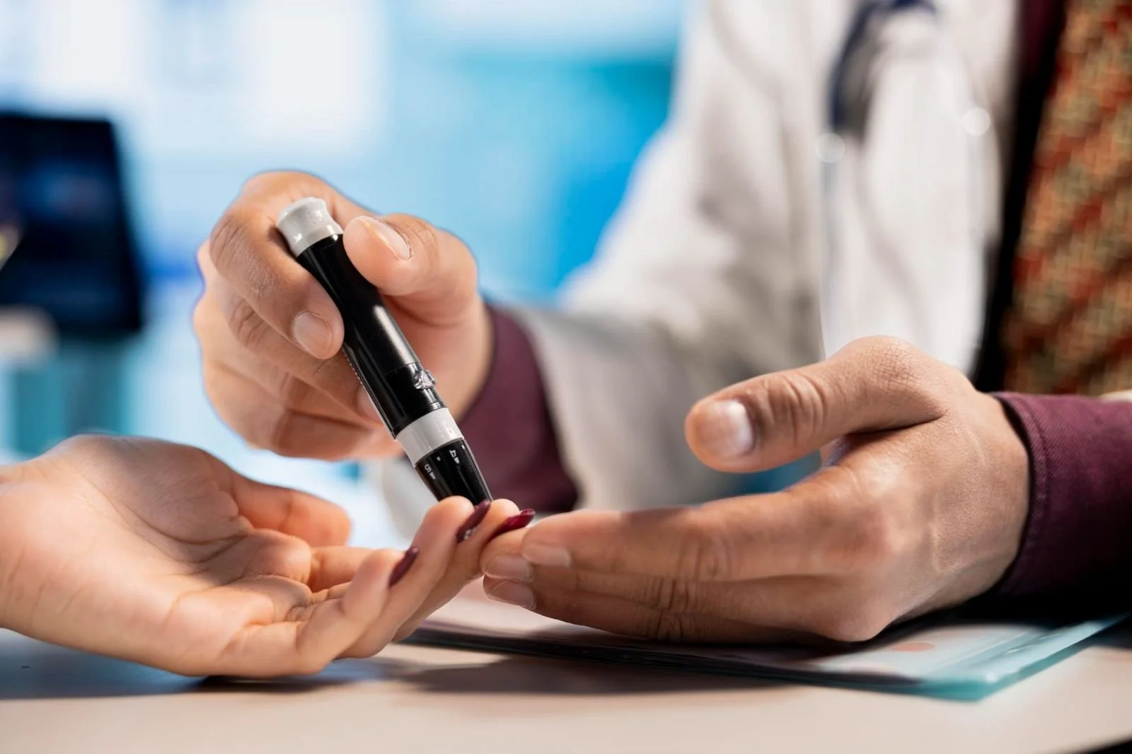 A healthcare professional using a device to test a patient's blood sugar level.