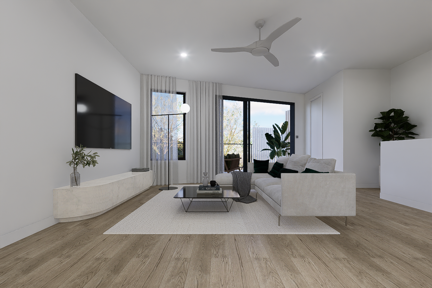 Living room with white walls, hardwood floors, a white sofa with black and green pillows, a glass coffee table, a flat-screen TV, large windows with sheer curtains, potted plants, and a white ceiling fan.