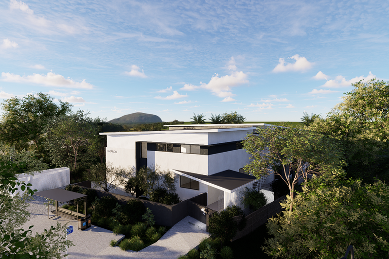 Modern white multi-story house surrounded by trees with a clear blue sky and clouds overhead.