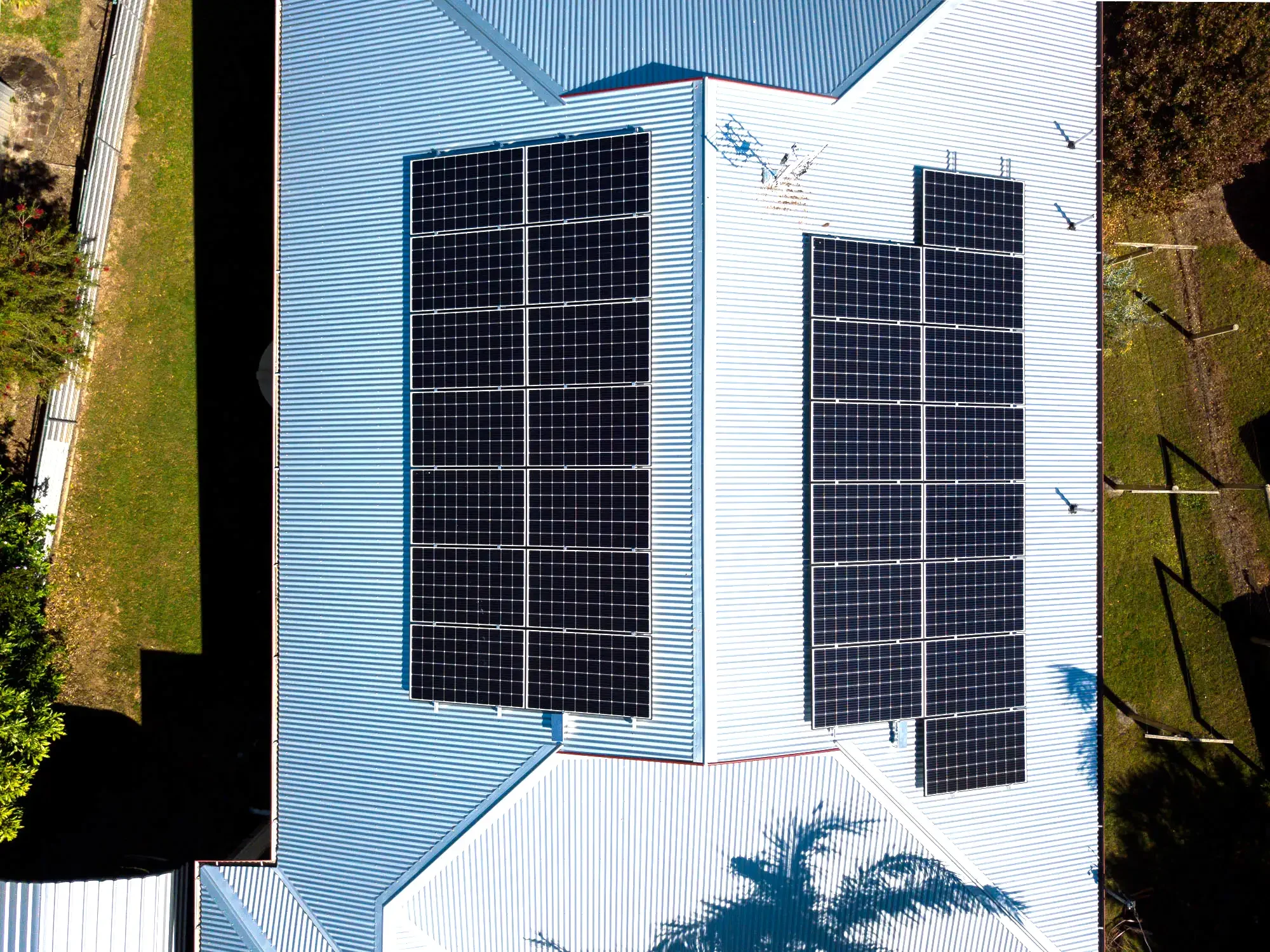 A house with a white metal roof equipped with multiple solar panels.