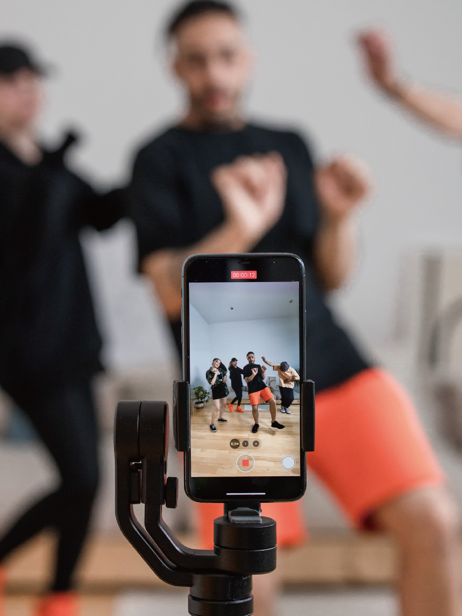 Influencers film short-form dance content on a phone gimbal for a social media campaign. Link Influence manages social content creations.