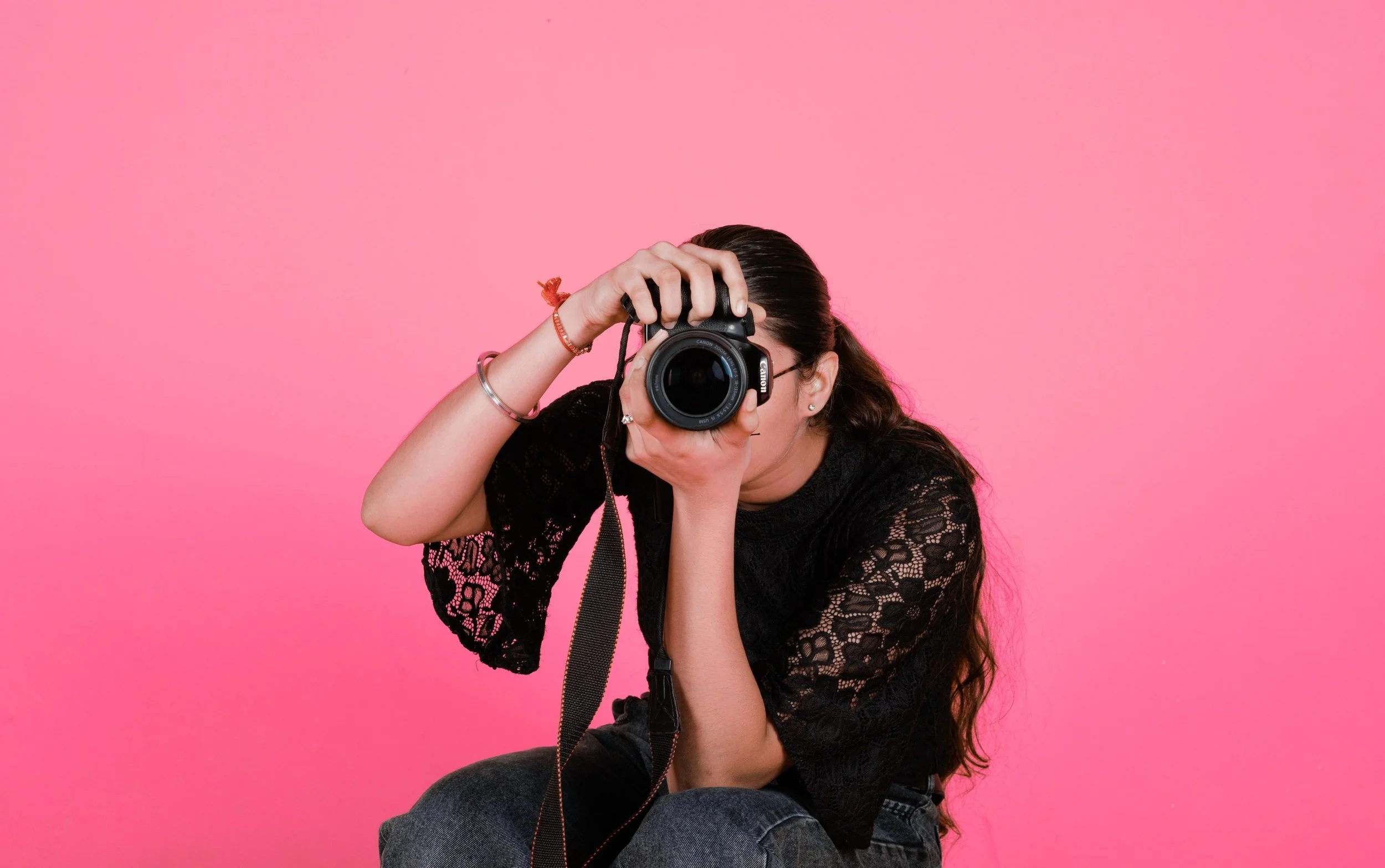 Woman taking a photo with a DSLR camera, representing Link Influence's commitment to creators, photography, and partnership opportunities.