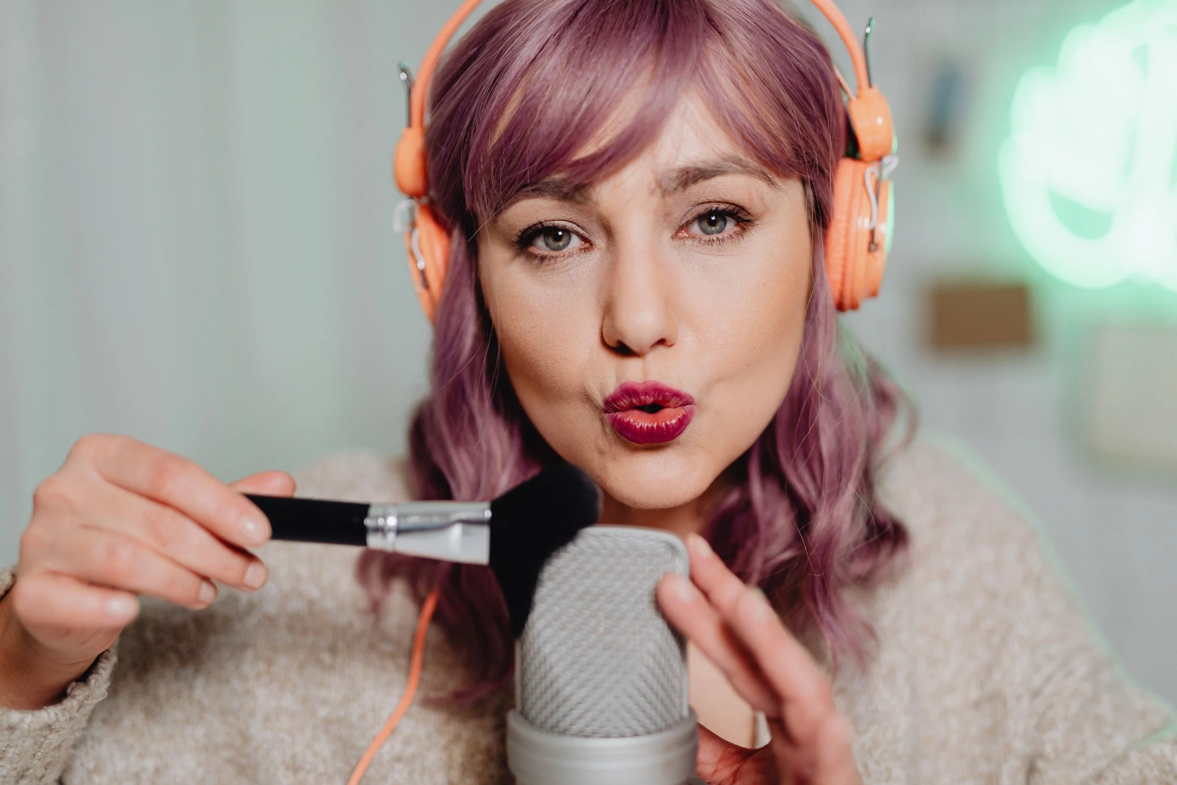 Beauty influencer with microphone and brush creating niche social media content, showing successful influencer selection and specialized campaign coordination