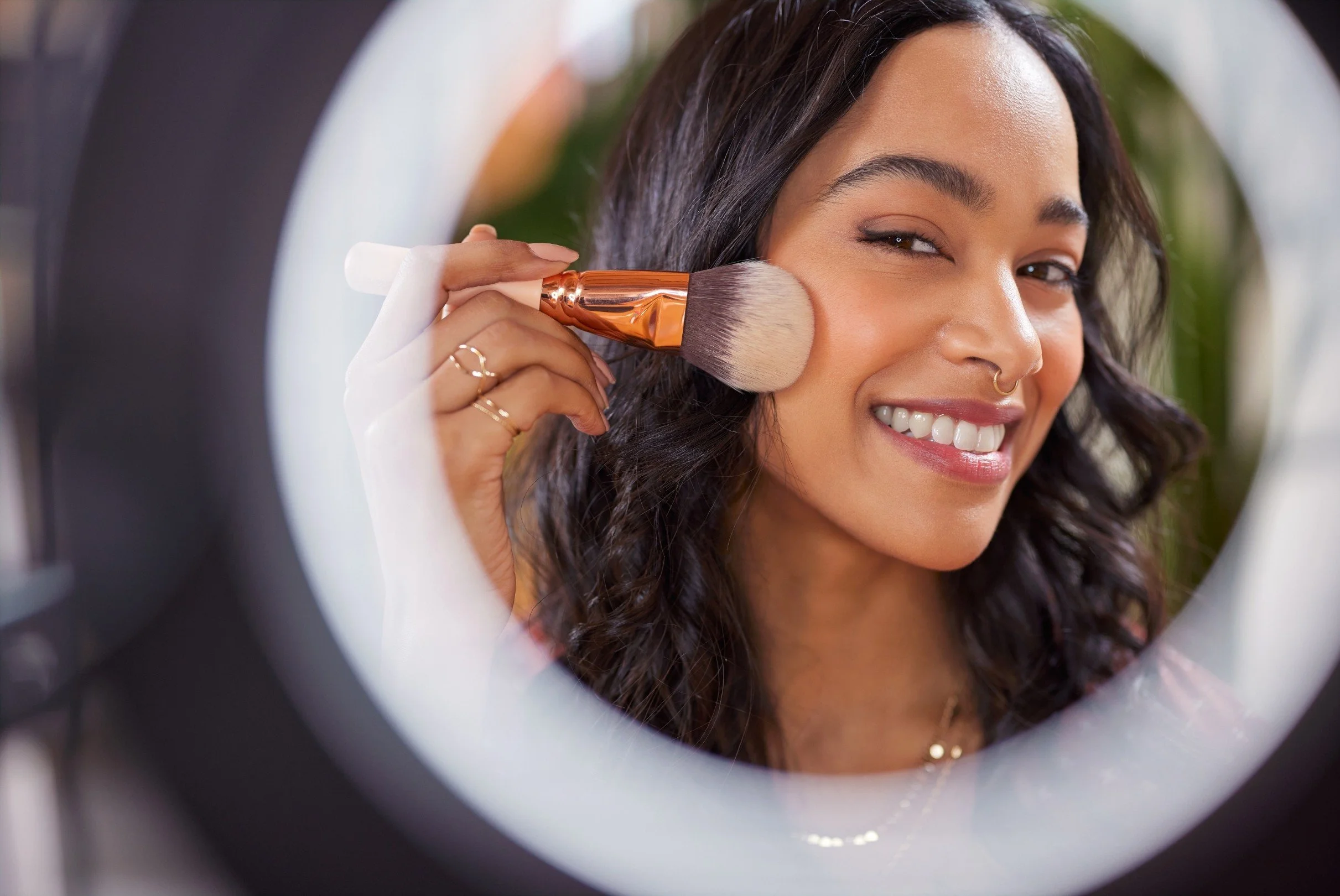 Beauty influencer applying makeup in a ring light, demonstrating successful content creation and engagement, driven by expert influencer selection.