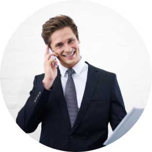 Smiling young man in a business suit talking on a mobile phone and holding a tablet.