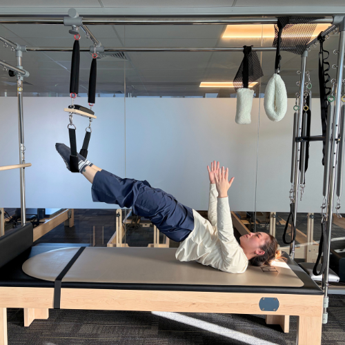 Woman practicing pilates on the cadilac