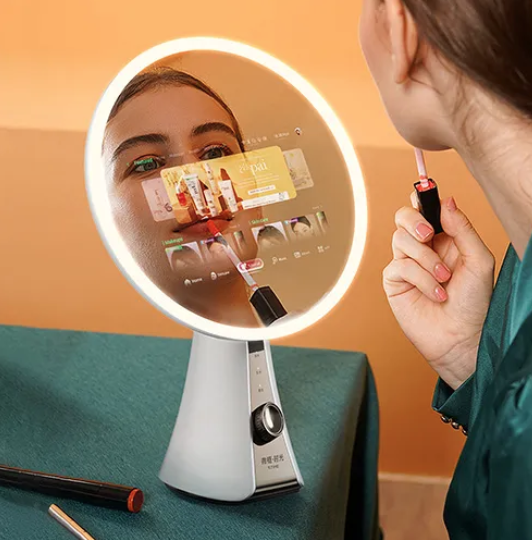 Person holding makeup brush looking into circular mirror with LED light on a table.