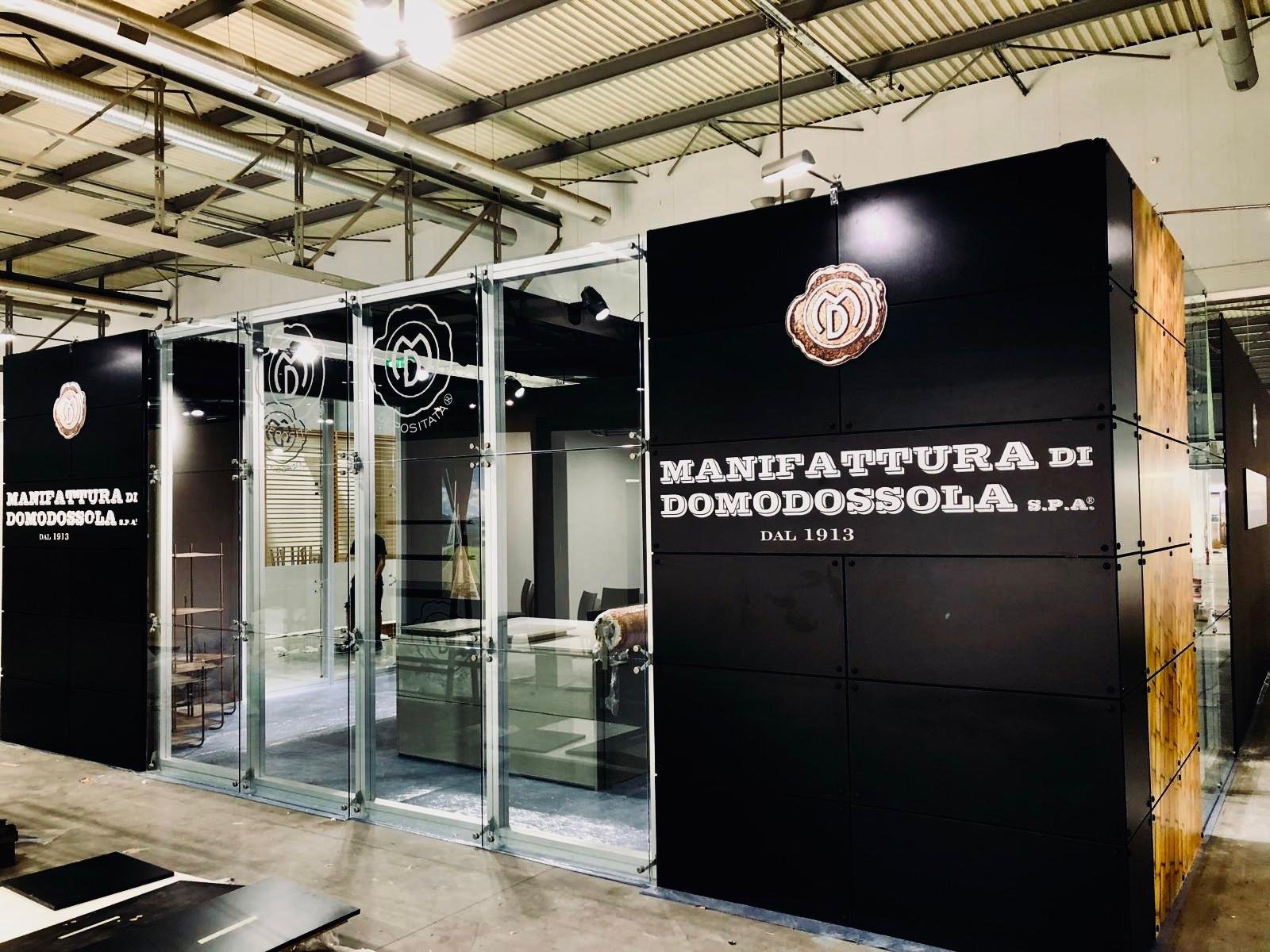 Insegna e finestra di un'azienda chiamata 'Manifattura di Domodossola' con logo e dettagli storici