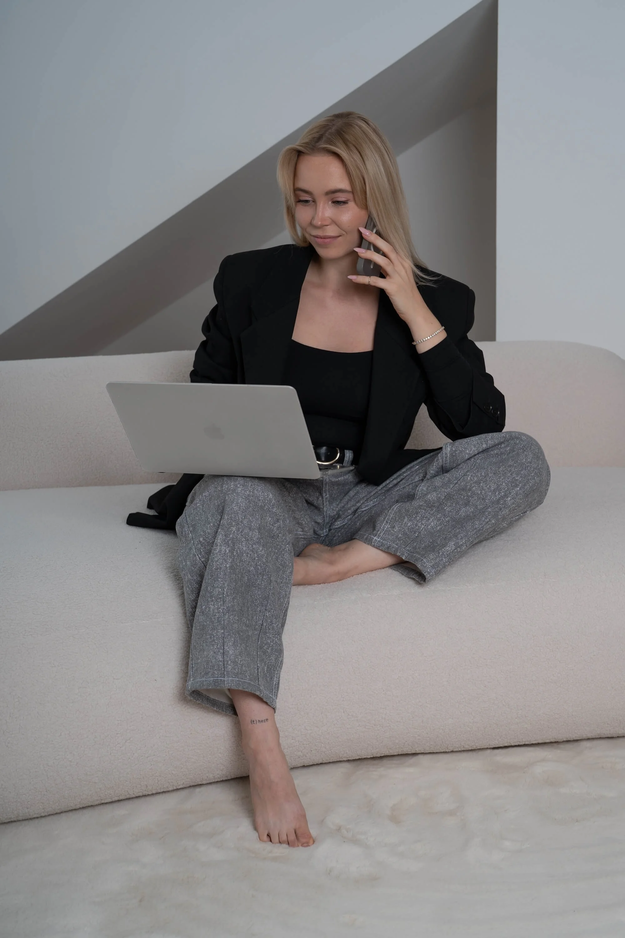 Webdesignerin Lena Brückner am Laptop und Telefon für eine Projekt-Abstimmung | Sitewise Webdesign | Squarespace Webdesigner Frankfurt am Main