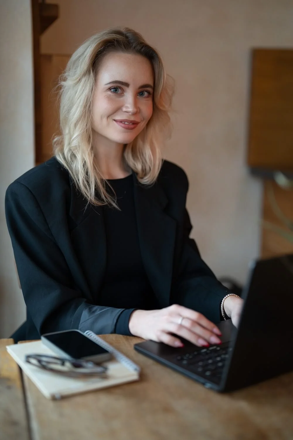 Webdesignerin Lena Brückner (blond, schwarze Jacke) sitzt lächelnd in einem Café | Sitewise Webdesign | Squarespace Webdesigner Frankfurt