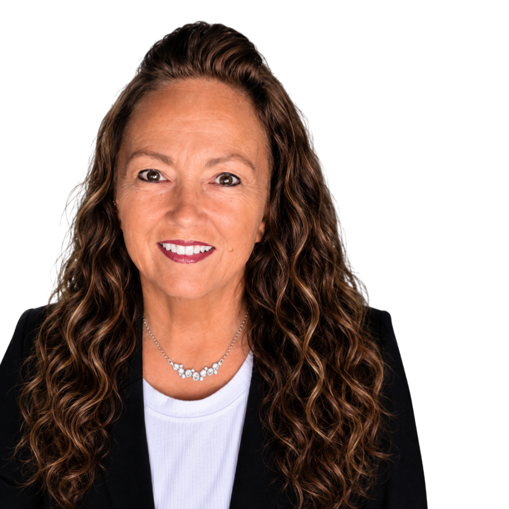 A woman with long, wavy brown hair wearing a black blazer, a white shirt, a silver necklace, and red lipstick, smiling.