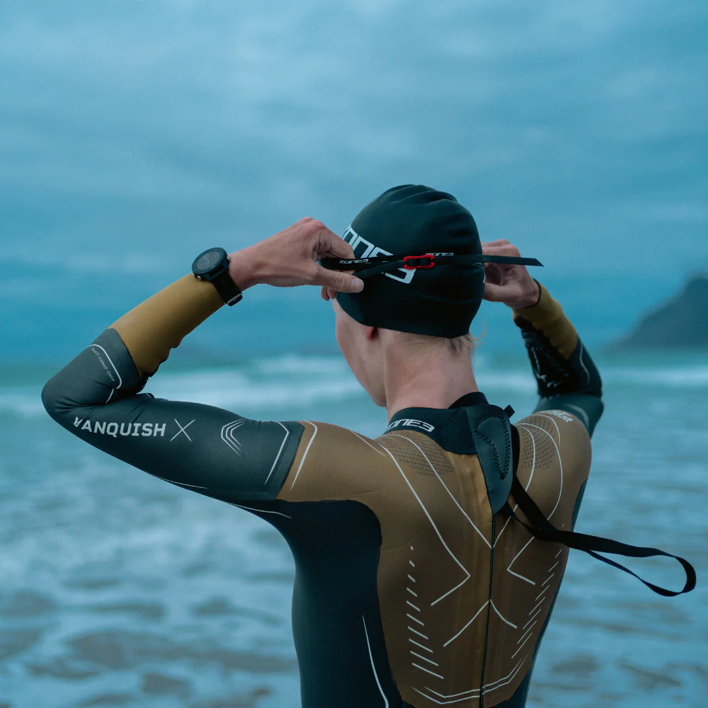 Swimmer adjusting cap and wetsuit before an open water swim.