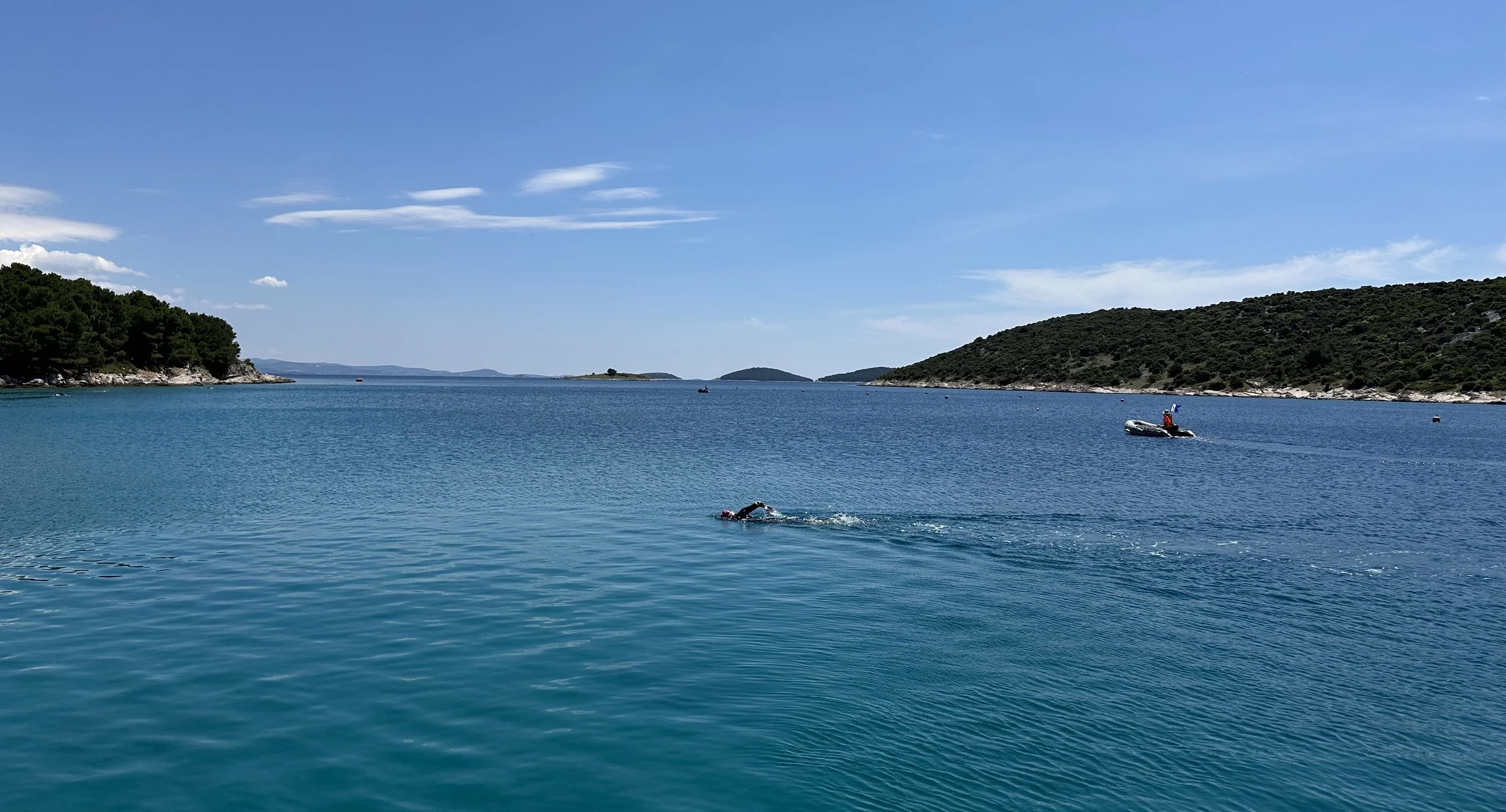 Swimmer training in calm open water as preparation for longer swims.