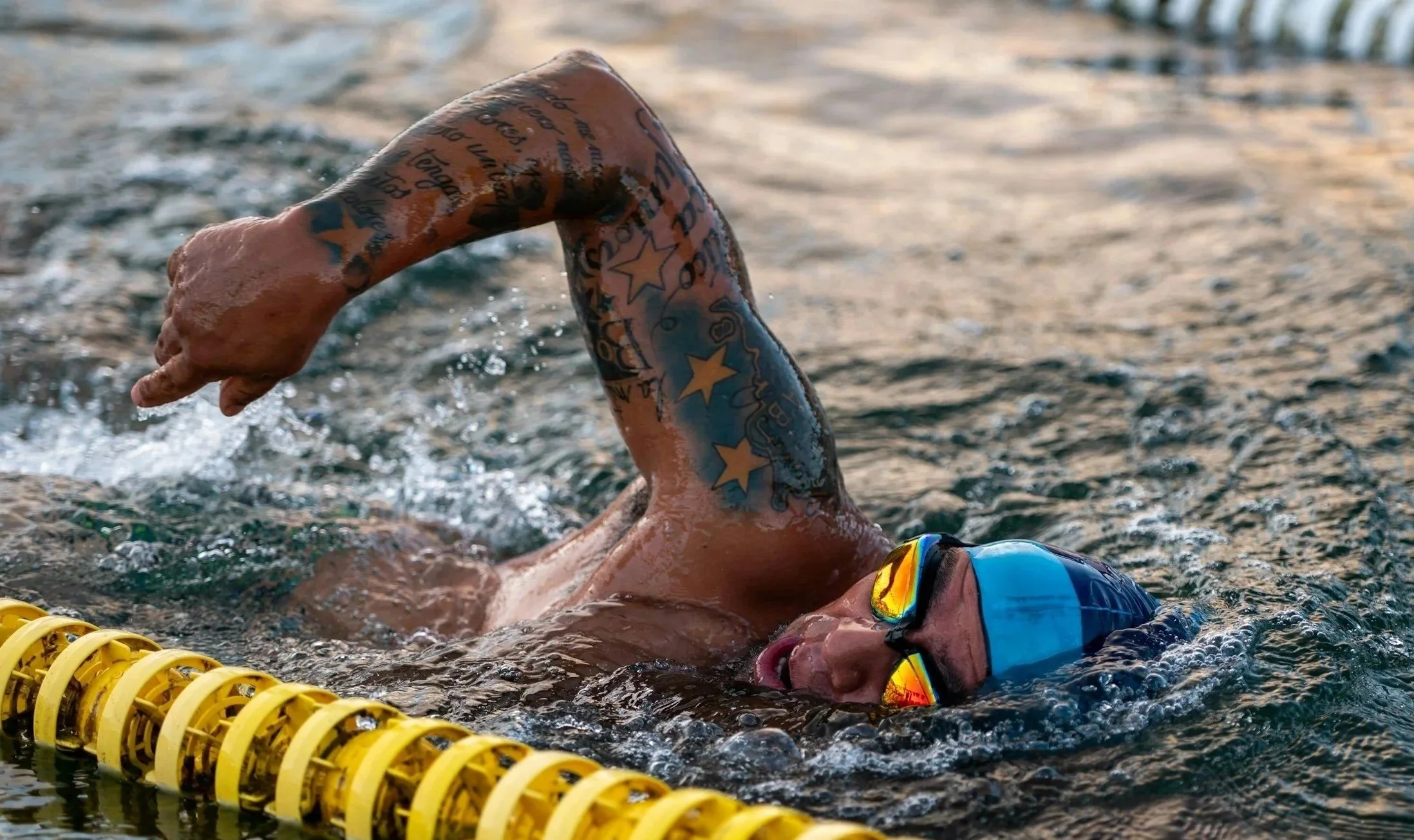 open water swimmer training in outdoor pool with cap and goggles