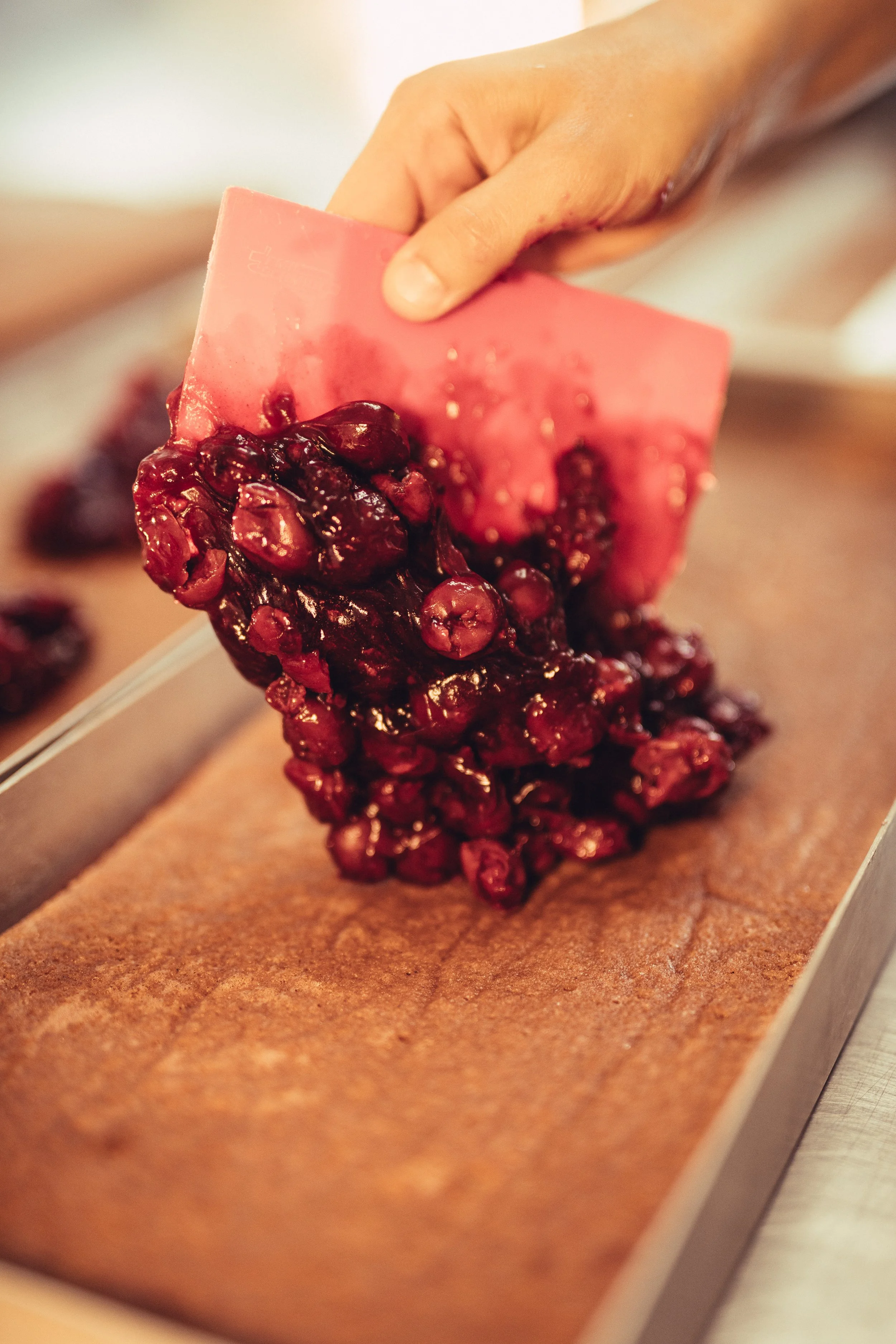Nahaufnahme eines Schokoriegels mit Beeren auf Backpapier, bereit zum Einschmelzen.