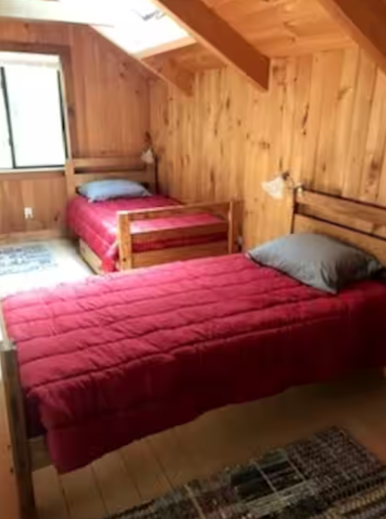 Loft bedroom with twin beds in family friendly Maine cottage