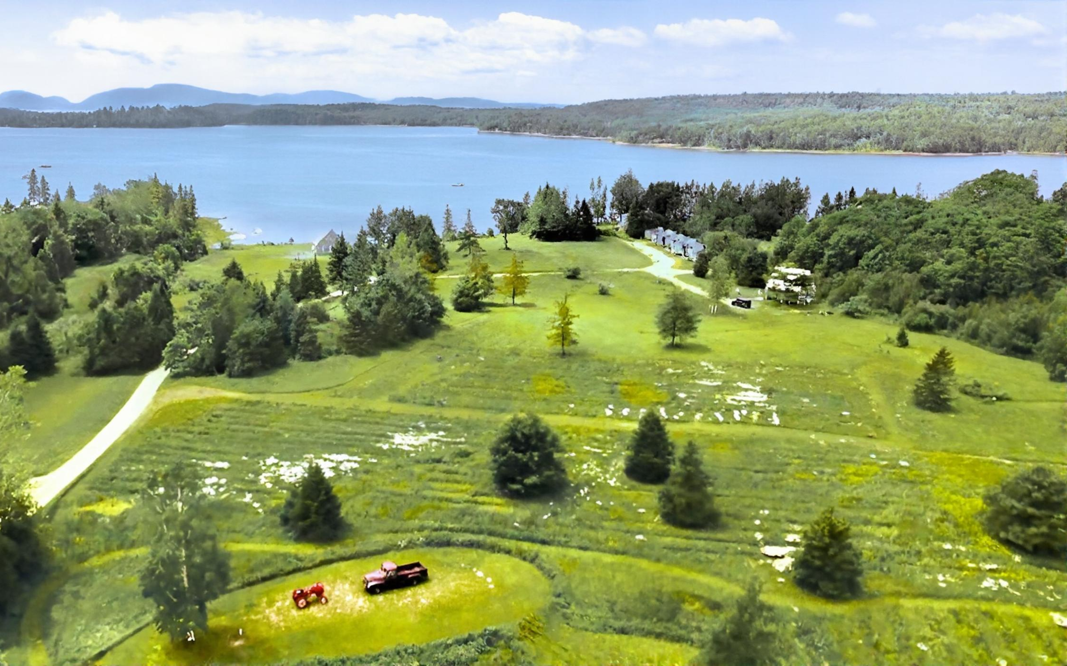 Aerial view of Flanders Bay waterfront property near Acadia National Park with lush lawns and Cadillac Mountain in the distance