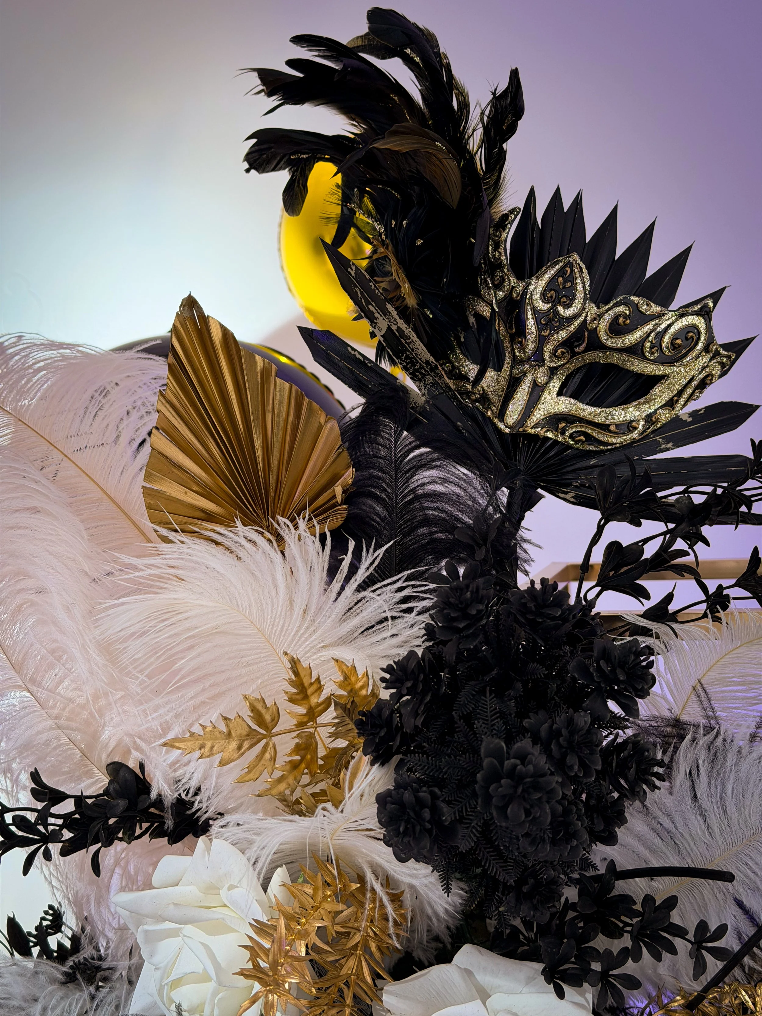 black, white and gold feathers, with masks