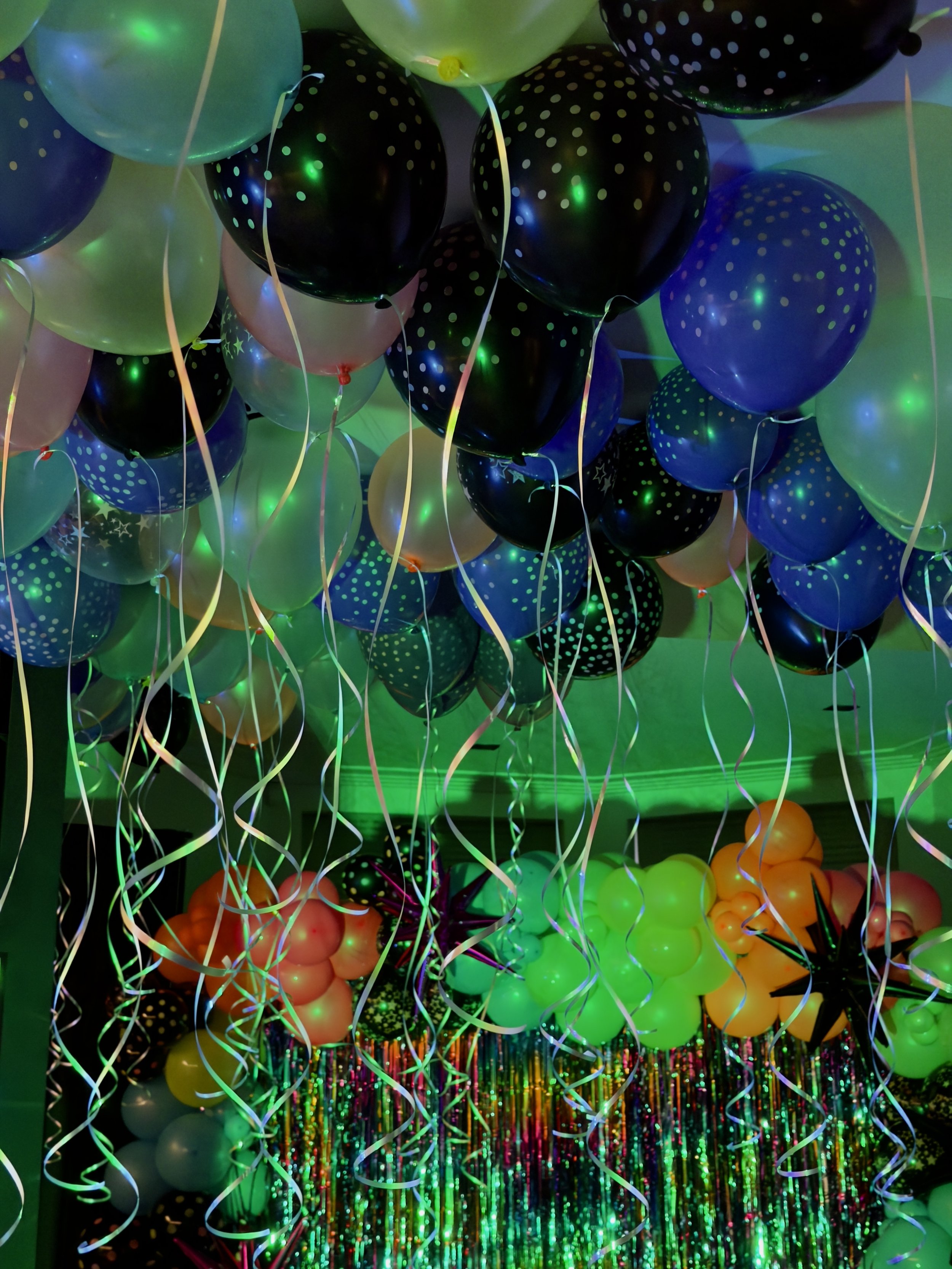 ceiling of glow in the dark balloons and backdrop