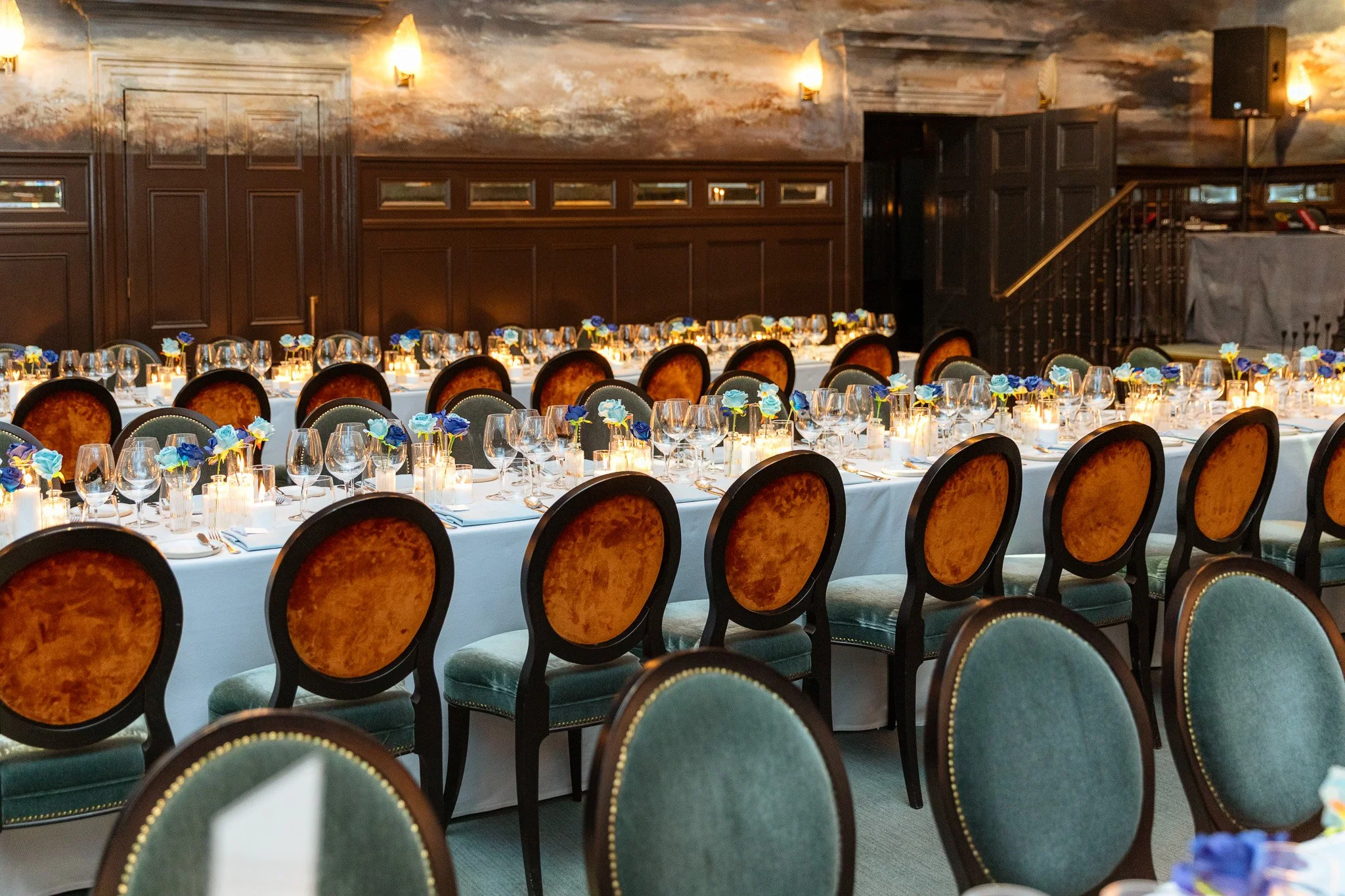 brown chairs on long table with roses and candles