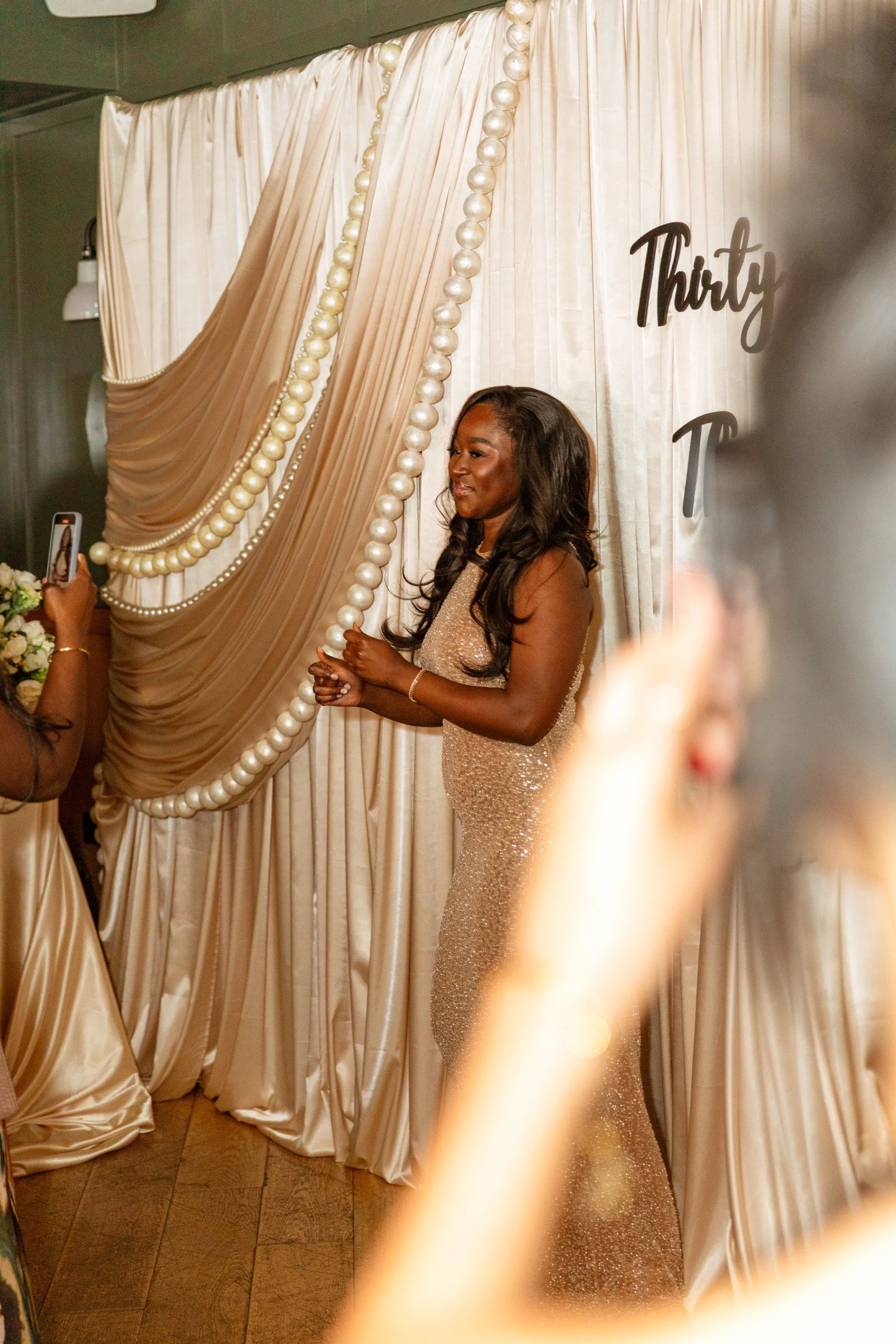 celebrant smiling in front of draped backdrop