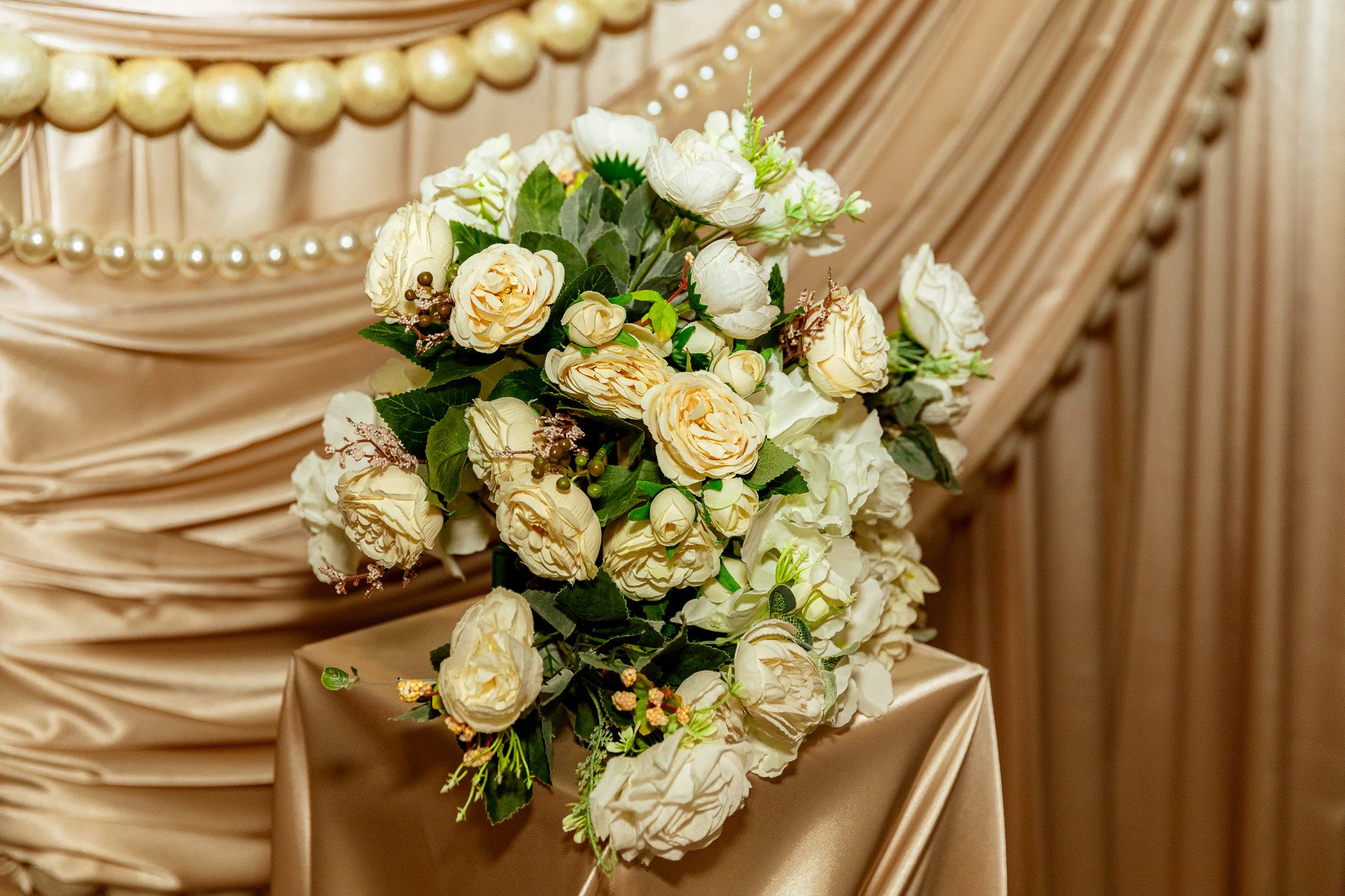 draped backdrop with flowers and pearls