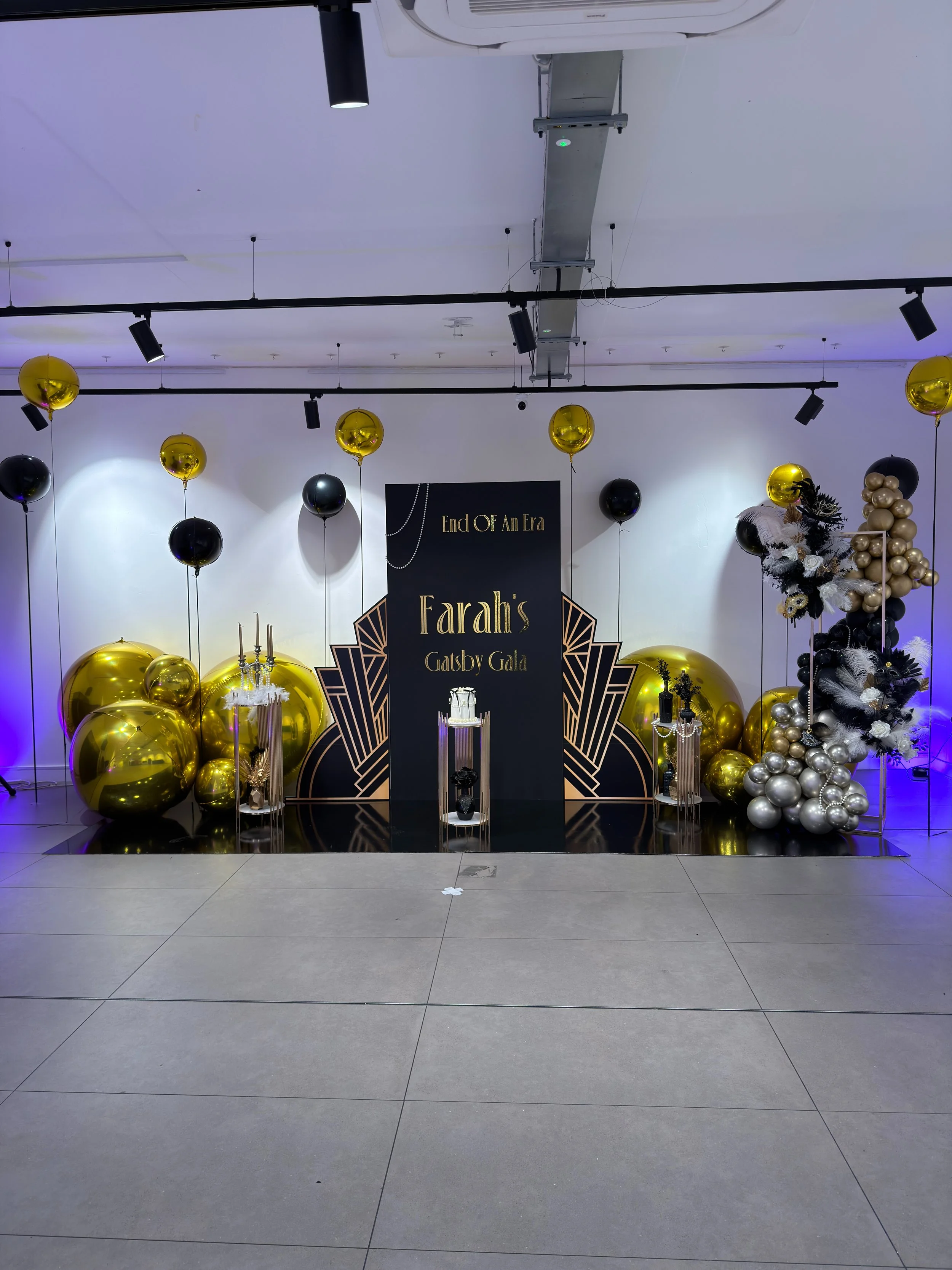 main backdrop, board with gold vinyl, black and gold floating balloons