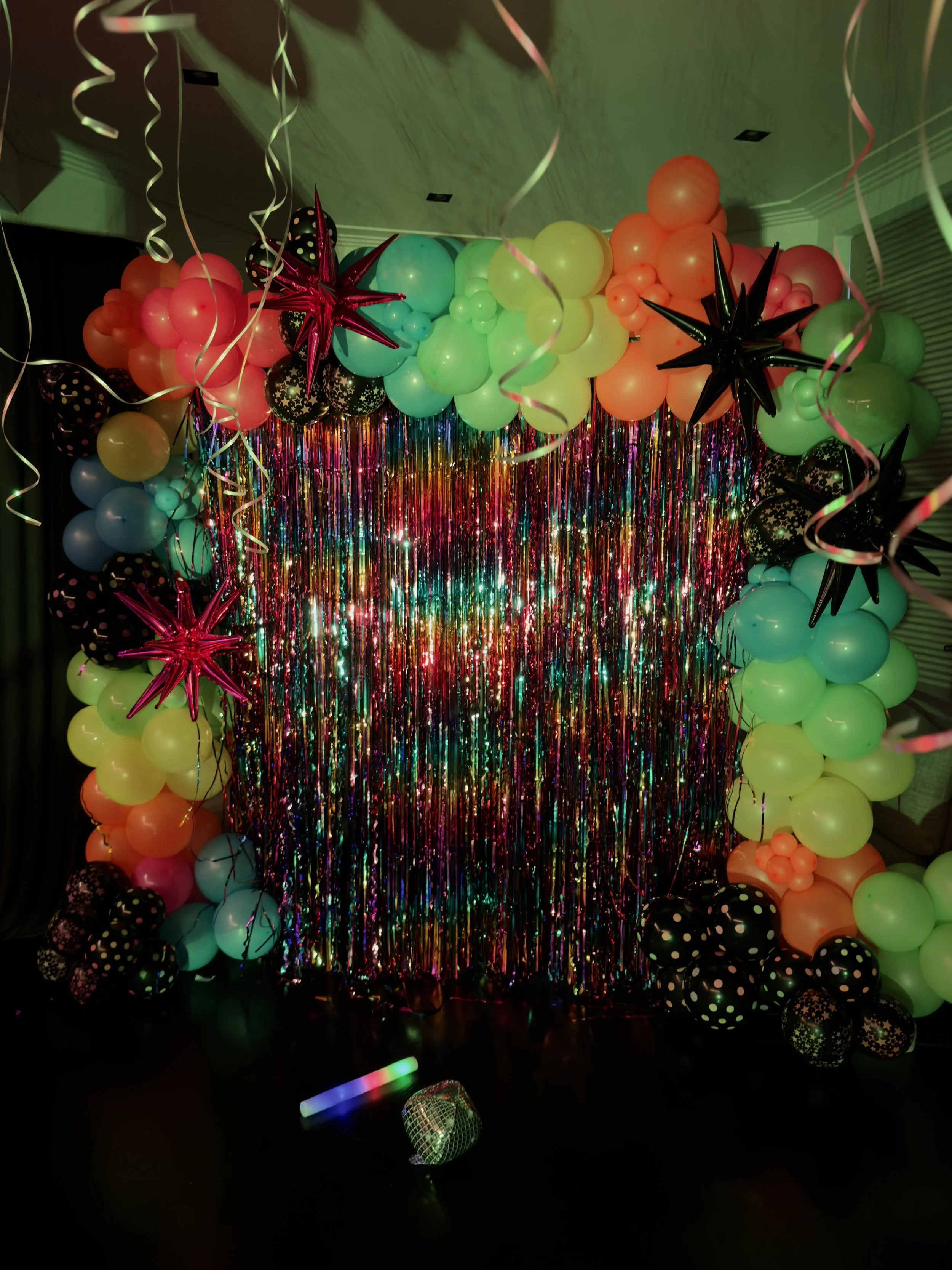 neon balloon arch with rainbow tassels