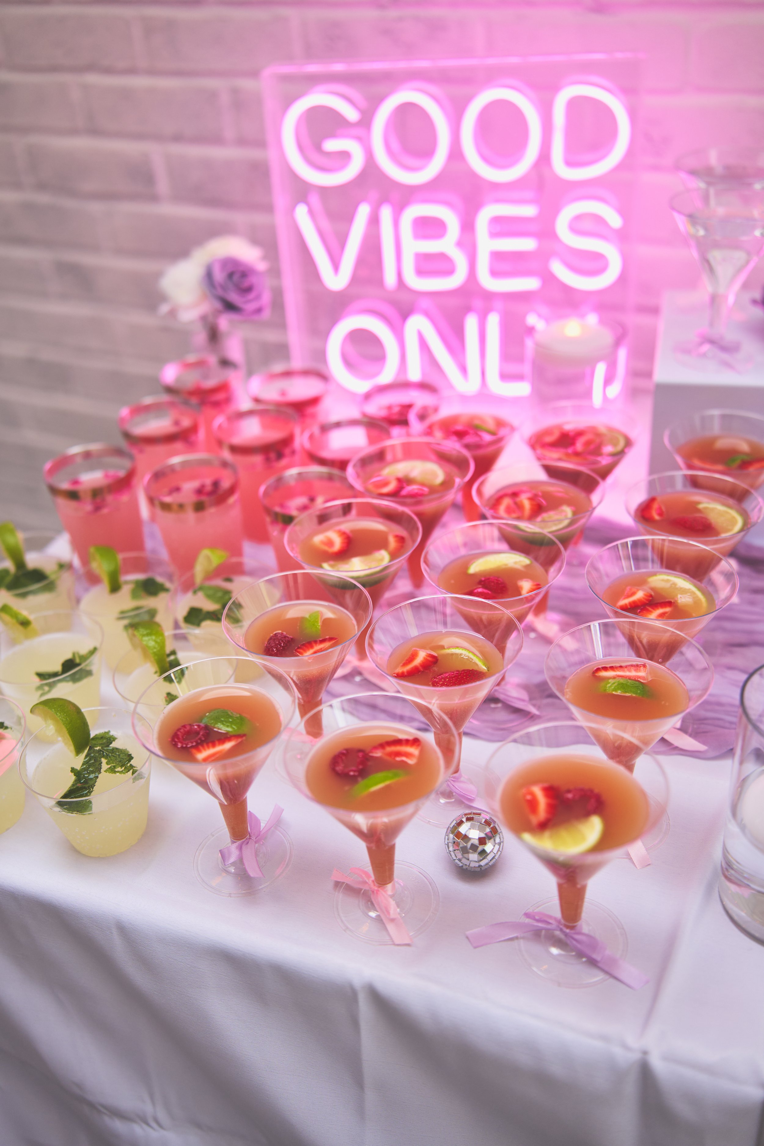 good vibes neon sign with different types of mocktails