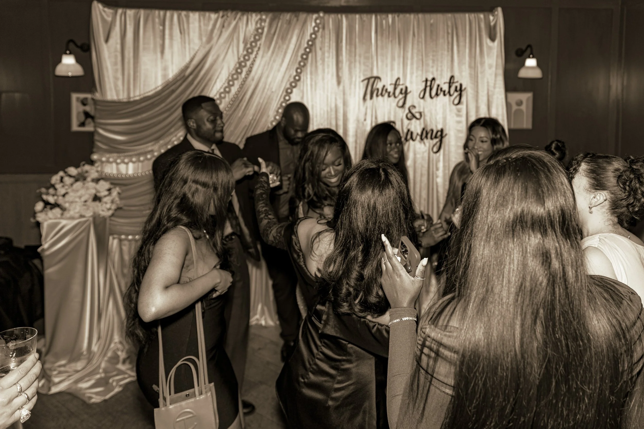 black and white picture of guests and draped backdrop