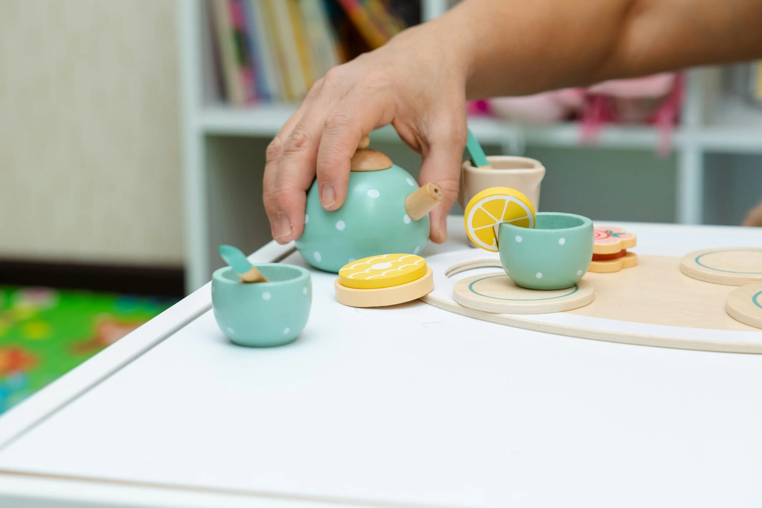 Play-based pediatric speech therapy activity with a child using a toy tea set to support communication and social interaction