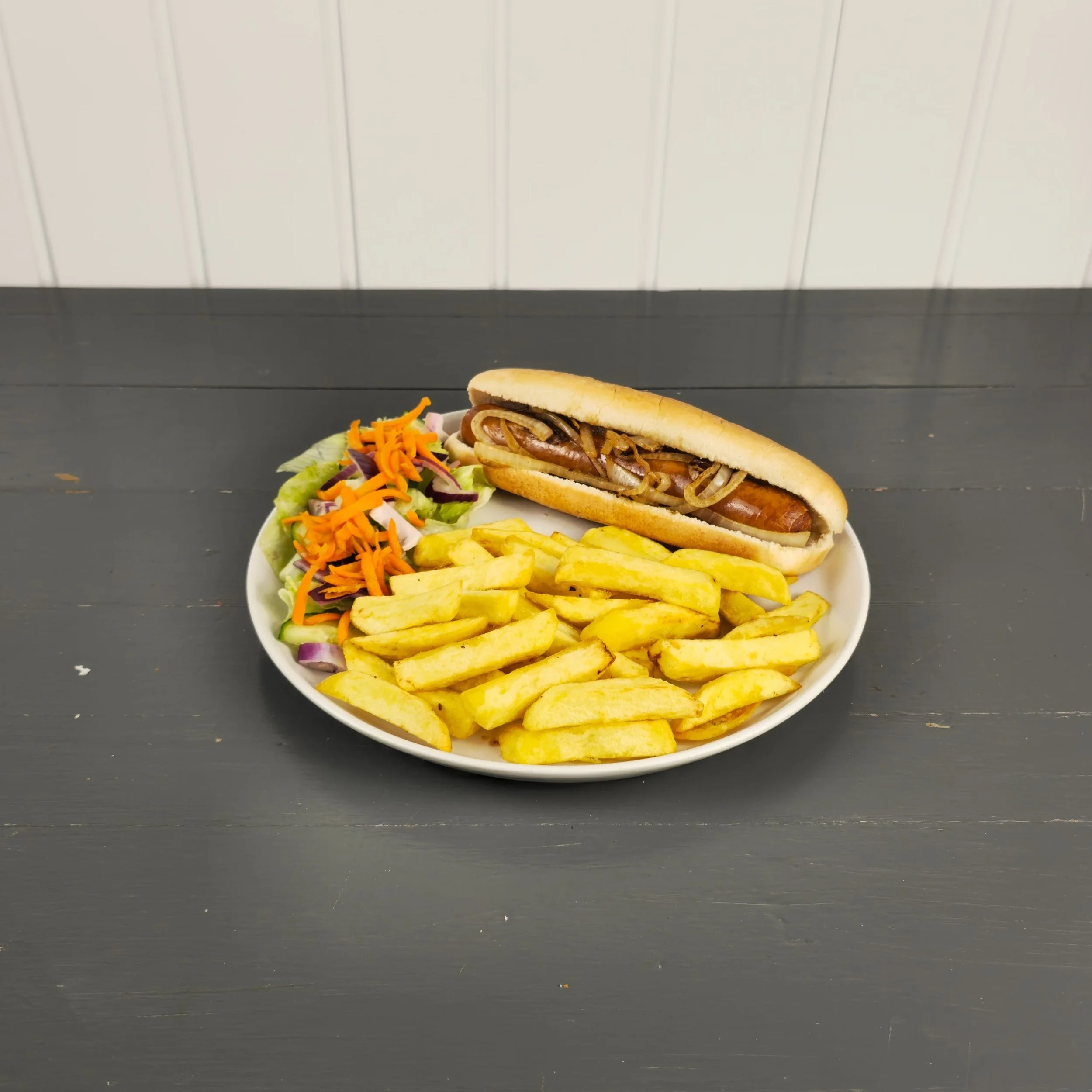 A tasty lunch option with a grilled hot dog topped with onions, served alongside golden chips and a fresh salad. This photo highlights Silverwood’s versatile daytime menu, perfect for promoting casual, satisfying meals for all ages.