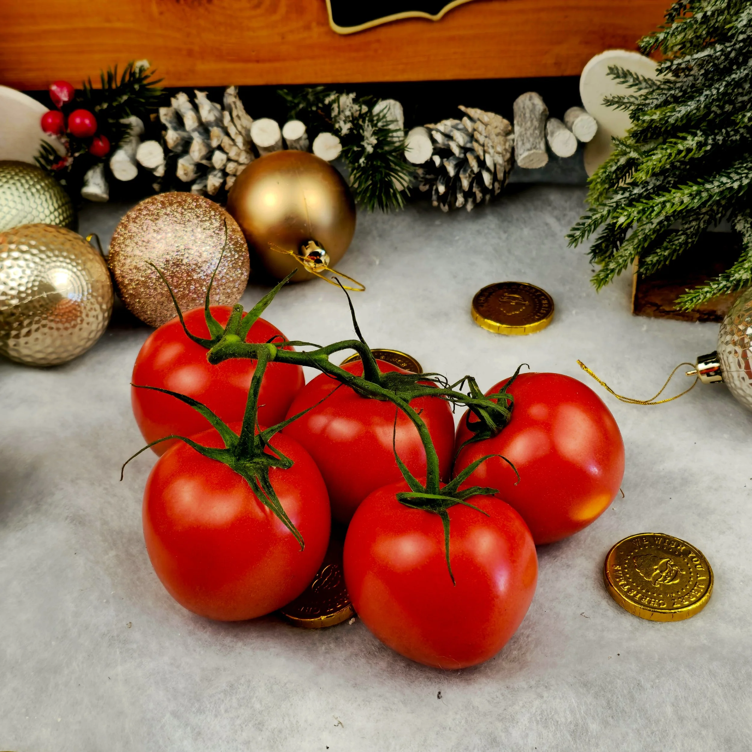 Glowing with freshness, a cluster of vine-ripened tomatoes rests among festive decor. The contrast of red fruit against gold and green tones gives the image warmth and depth. It’s a composition that balances the simplicity of produce photography with